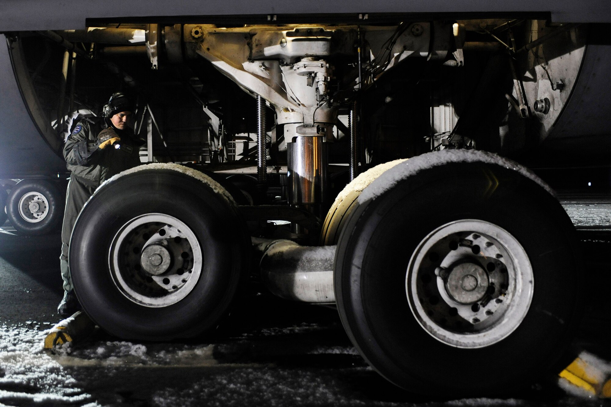 Master Sgt. Jorge Orama checks for leaks on a C-5M Super Galaxy's landing gear after a cold weather test Dec. 14 at Eielson Air Force Base, Alaska. This is the first C-5M with the new CF-6 engines, pylons and auxiliary power units, with upgrades to the aircraft's skin and frame, flight controls, landing gear and the pressurization system that went through cold weather testing. Sergeant Orama is assigned to the Air Mobility Command Test and Evaluation Squadron Det. 1 at Edwards AFB, Calif. (U.S. Air Force photo/Senior Airman Jonathan Snyder) 
