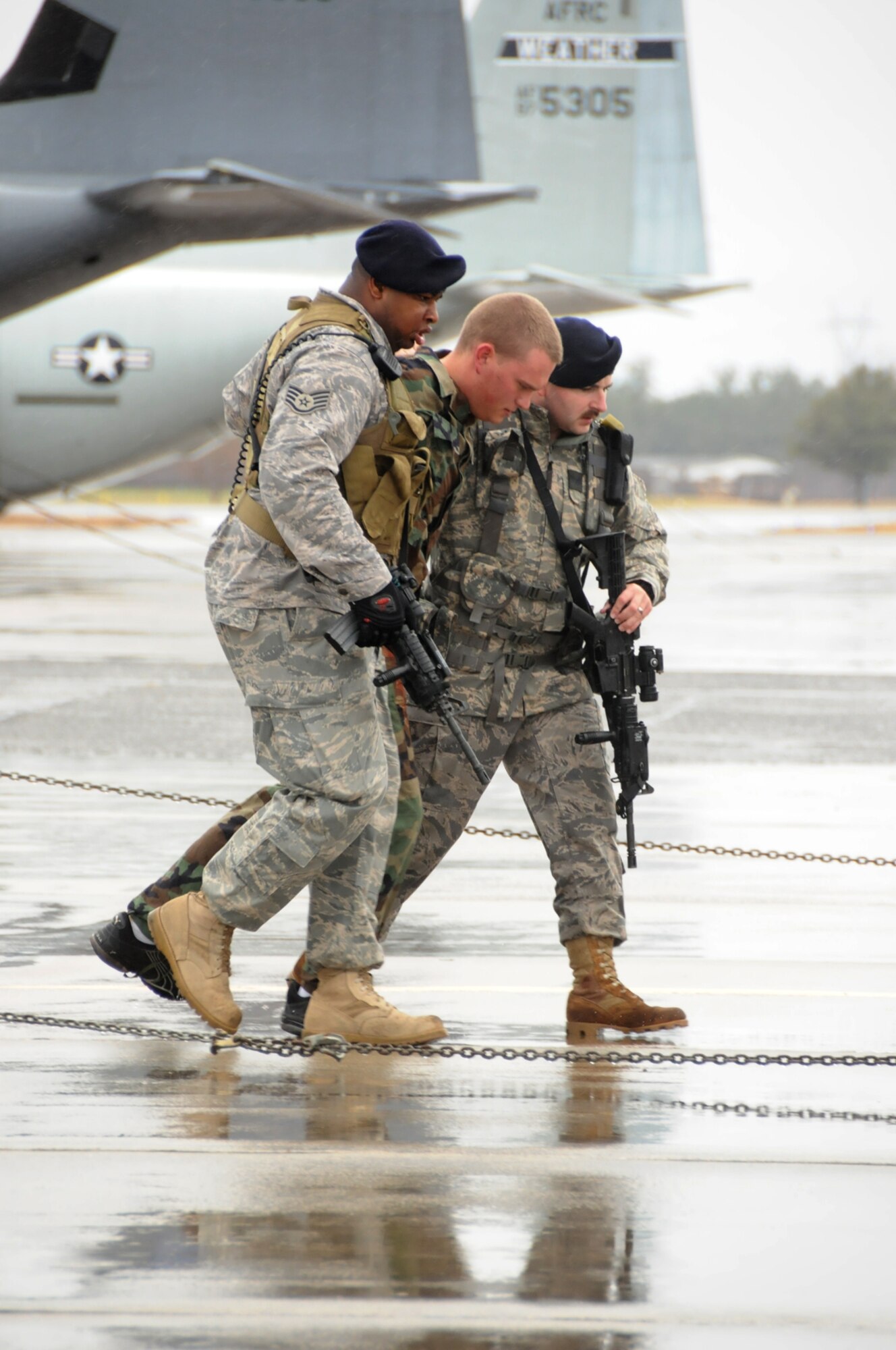Staff Sgts. Jonathan Garner, left, and Christopher Pike, right, 81st SFS, assist Airman Basic Samuel Nabakowski, who portrayed a person whose leg was injured during the hijacking attempt.  Airman Nabakowski is a student in the 334th TRS.  (U.S. Air Force photo by Kemberly Groue)