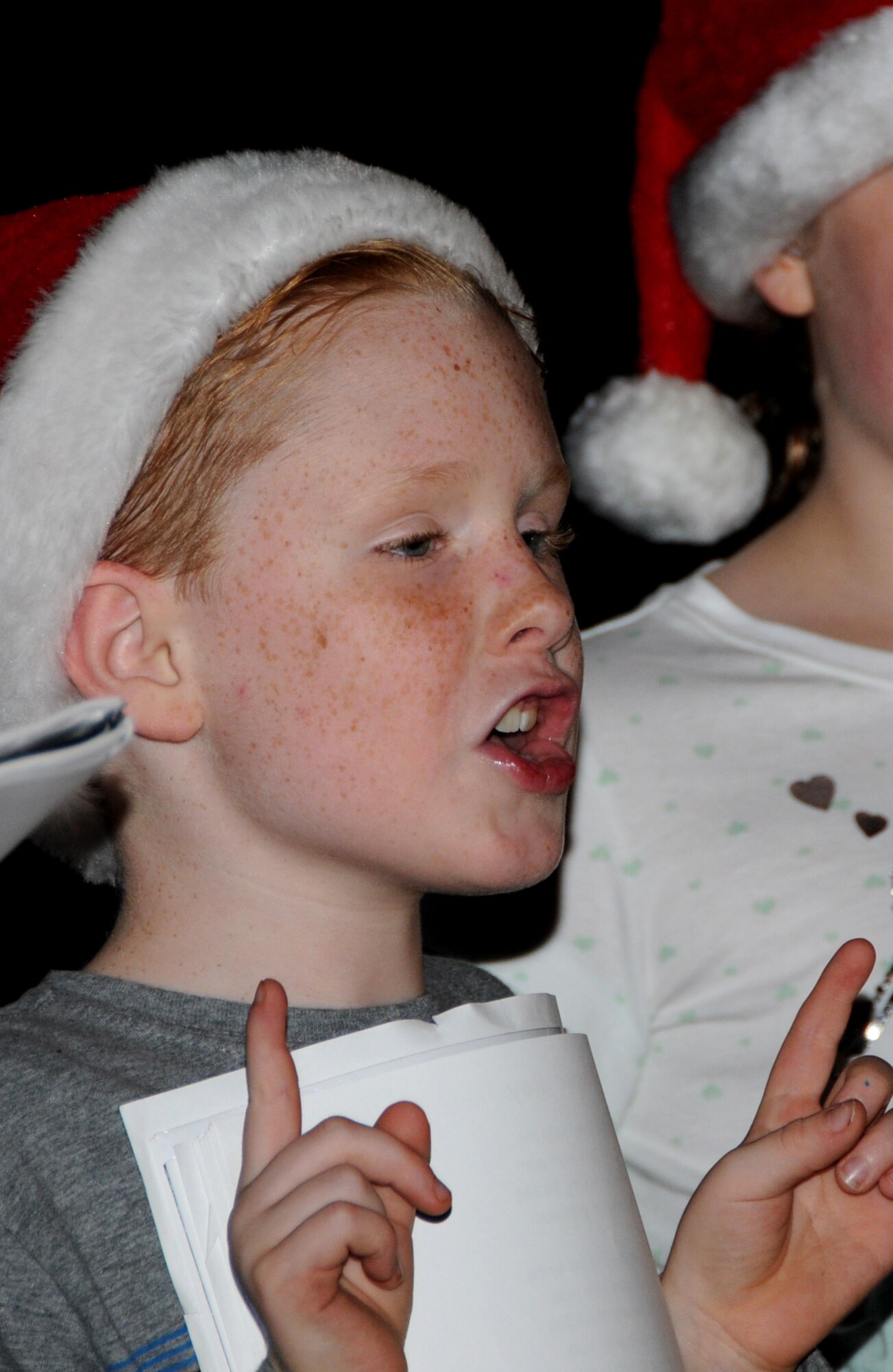 Aidan Naylor, son of Col. Richard Naylor, 2nd Air Force, and Suzanne, sings Christmas carols  with friends in the Bay Ridge housing area Monday.  (U.S. Air Force photo by Kemberly Groue)