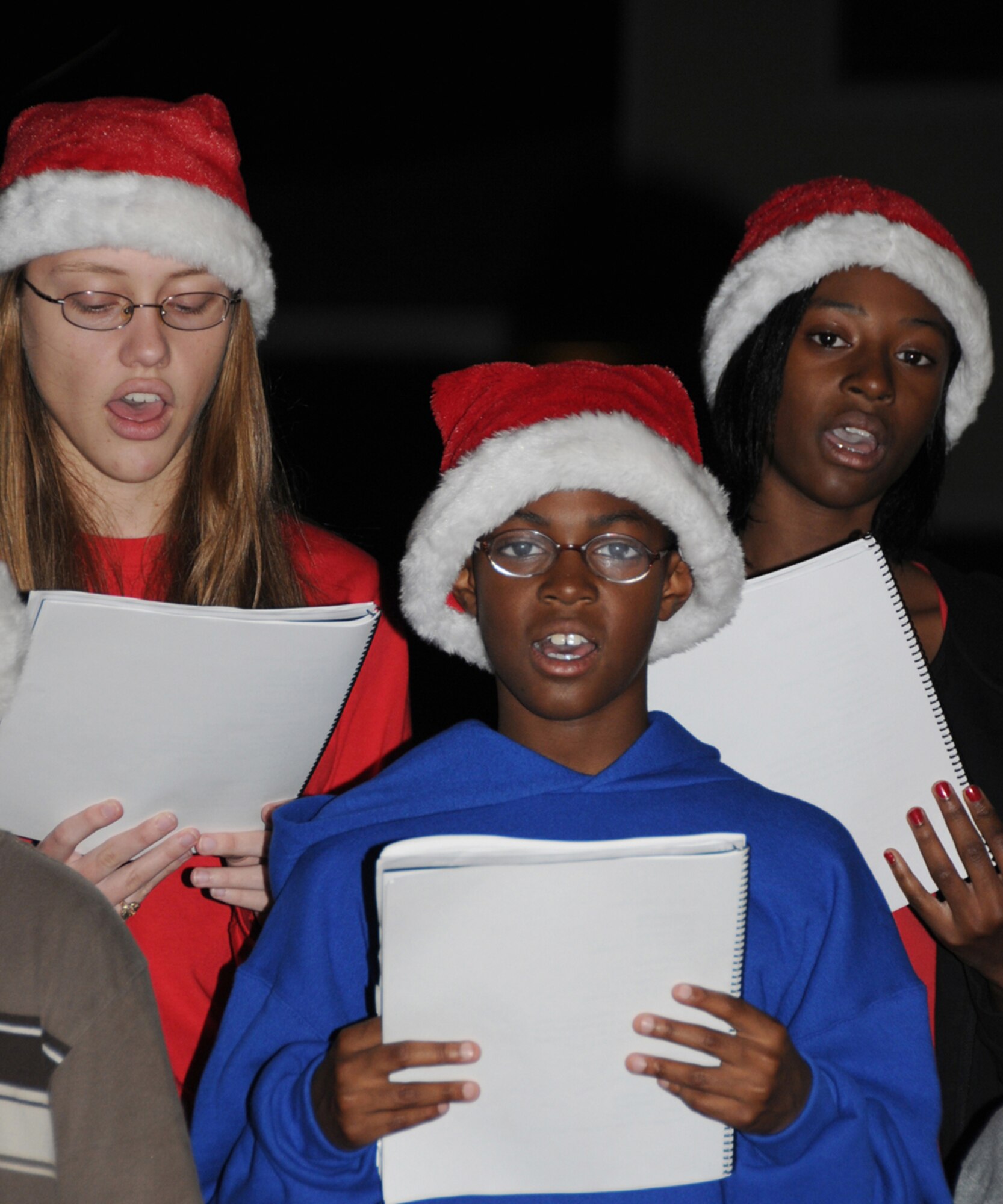 From left, Sarah Ramsay, 16, daughter of Lt. Col. Steven Ramsay, 81st Training Group deputy commander,  and Leanne Ramsay; sing with Joshua Gilliard, 8, and Jordan Gilliard, 12, son and daughter of Col. Prince Gilliard, 81st TRG commander and Wanda Gilliard.  The children caroled in the Bay Ridge housing area Monday.  (U.S. Air Force photo by Kemberly Groue)
