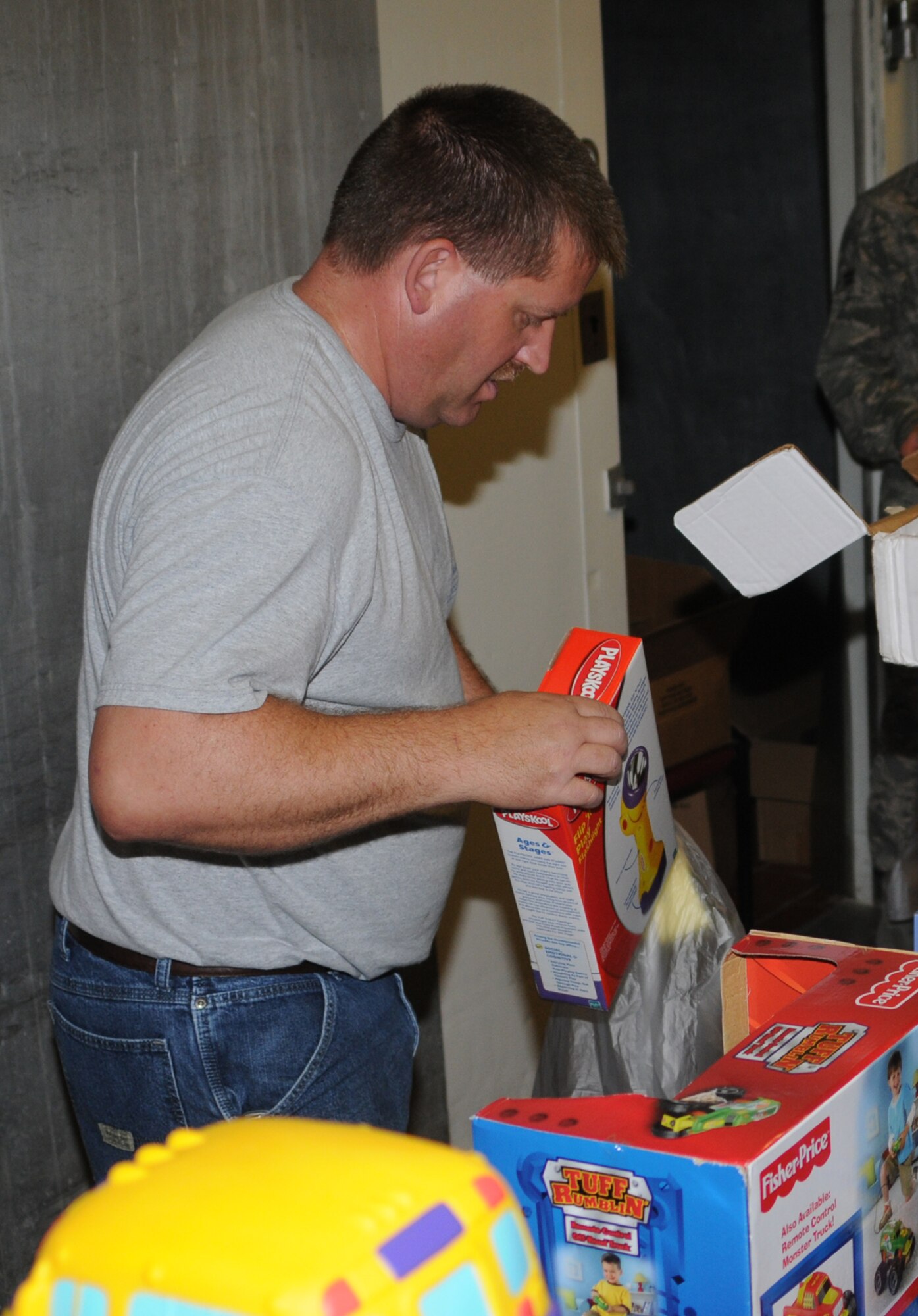 John Lowe puts a toy into a bag Monday, Dec. 15.  Mr. Lowe is heading the toy distribution through Project Cheer and worked with the Salvation Army to acquire toys for more than 122 Keesler children.  Keesler first sergeants picked up toys for distribution on Dec. 17.  (U.S. Air Force photo by Tech. Sgt. Chuck Marsh)