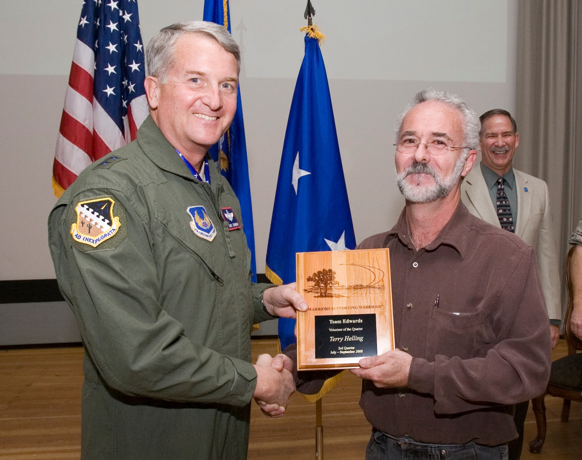 Terry Helling, 95th Force Support Squadron logistics project manager, receives the Volunteer of the 3rd Quarter award from Maj. Gen. David Eichhorn, Air Force Flight Test Center commander, during an award ceremony at the base theater Dec. 12. (Air Force photo by Jet Fabara)