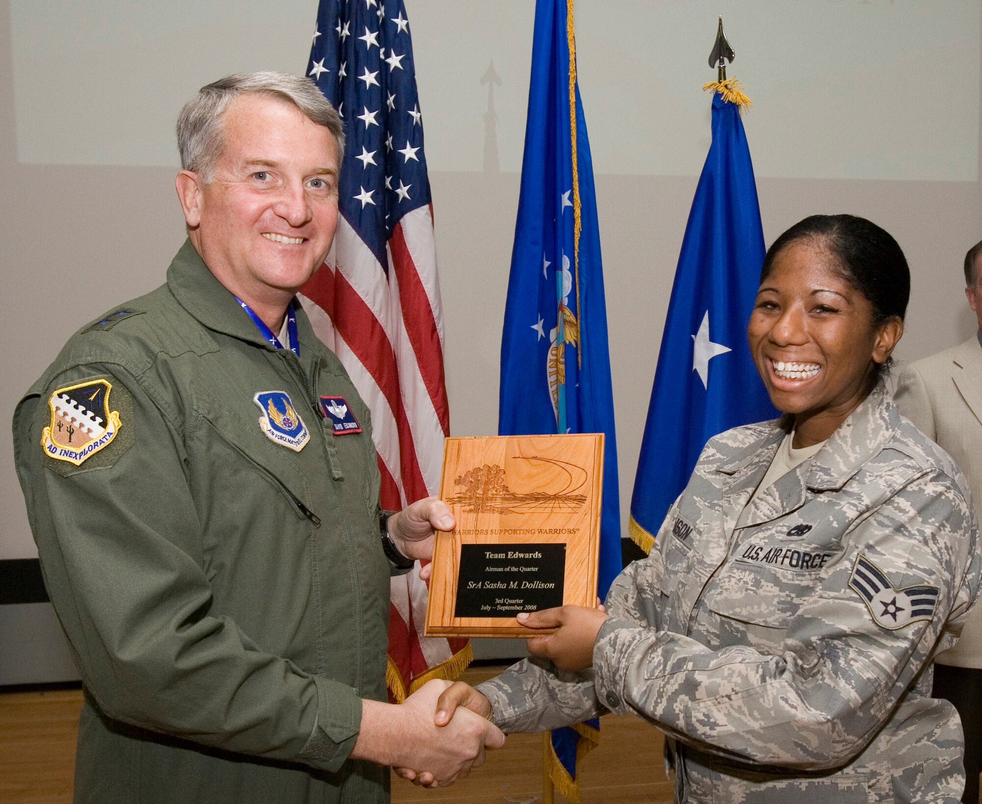 Senior Airman Sasha Dollison, 412th Maintenance Squadron precision measurement equipment laboratory journeyman, receives the Airman of the 3rd Quarter award from Maj. Gen. David Eichhorn, Air Force Flight Test Center commander, during an award ceremony at the base theater Dec. 12. (Air Force photo by Jet Fabara)