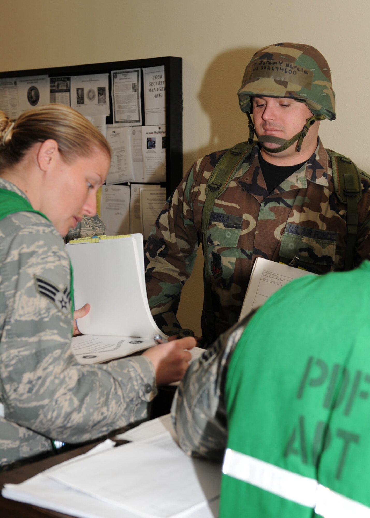 DYESS AIR FORCE BASE, Texas -- Staff Sergeant Jeremy Nepela, from the 7th Contracting Squadron, has his mobility folder inspected on the deployment processing line during an operational readiness exercise here, Dec. 15. Airman working on the processing line inspect mobility status, medical records, and identification cards to ensure every Airman is ready to deploy at a moment?s notice. (U.S. Air Force photo/Senior Airman Jennifer Romig)