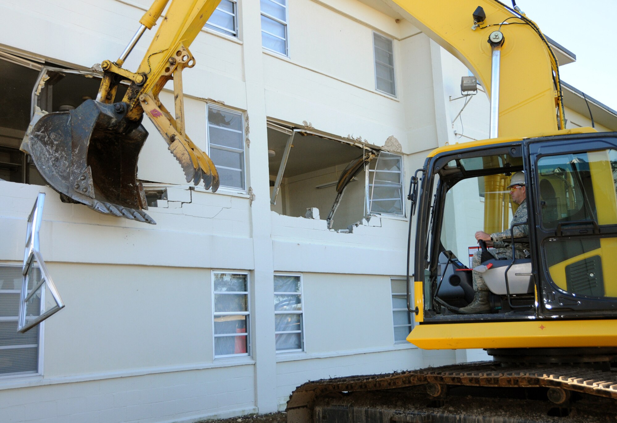 Brig. Gen. Greg Touhill, 81st Training Wing commander, uses an excavator to begin demolition of Avery Manor, one of the old dormitories in the Triangle, Dec. 12.  There are no plans to redevelop the area since it’s in the airfield clear zone, according to 1st Lt. Justin Delorit, 81st Civil Engineer Squadron.  Also, the lieutenant mentioned an initiative for bases to reduce their physical footprint by 20 percent by removing old buildings that are no longer needed.  (U.S. Air Force photo by Kemberly Groue)