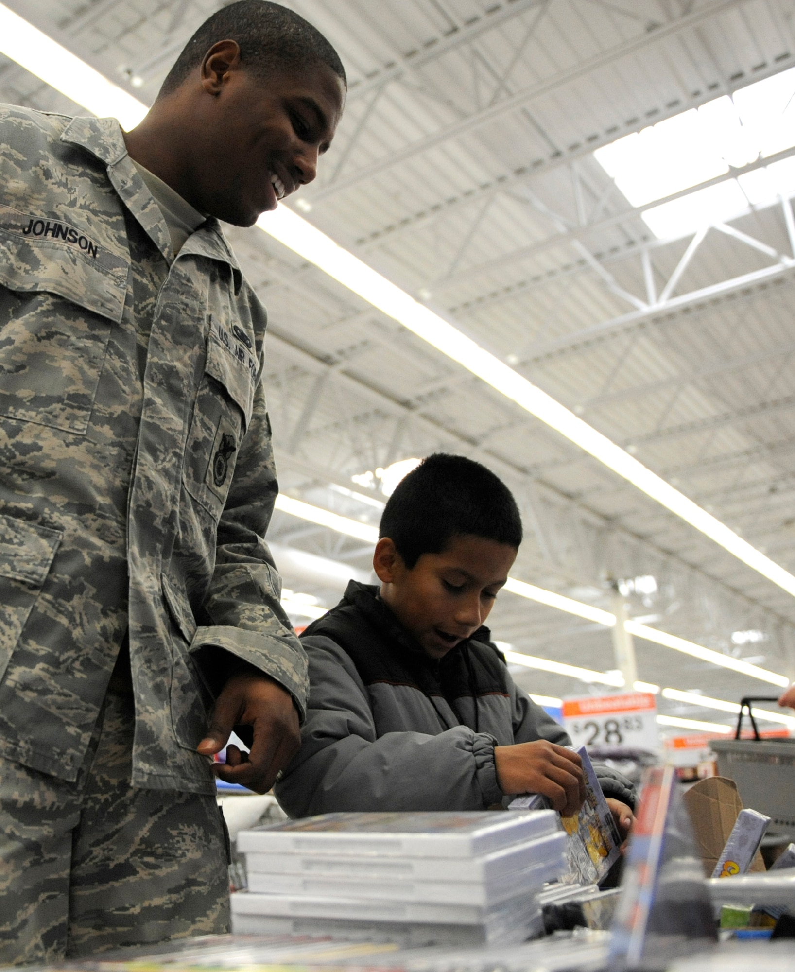 MOUNTAIN HOME AIR FORCE BASE, Idaho - Staff Sgt. Christopher Johnson, 366th Security Forces Squadron, helps a boy pick out a gift during the Mountain Home annual Shop with a Cop day held at the Wal-Mart in Mountain Home Dec. 3. Each year, the Mountain Home Police Department and the community of Mountain Home sponsor the annual Shop with a Cop day. More than 20 366th SFS Airmen participated in this year's event. Also attending the event were members of the Air Force Office of Special Investigations, Mountain Home Police Department, Elmore County Sheriffs Department, Army military police, Mountain Home Fire Department and Mountain Home Citizens on Patrol. More than 110 local needy children between the ages of 5 and 12 participated this year with more than $10,000 donated by local businesses. (U.S. Air Force photo/Airman 1st Class Stephany Miller)