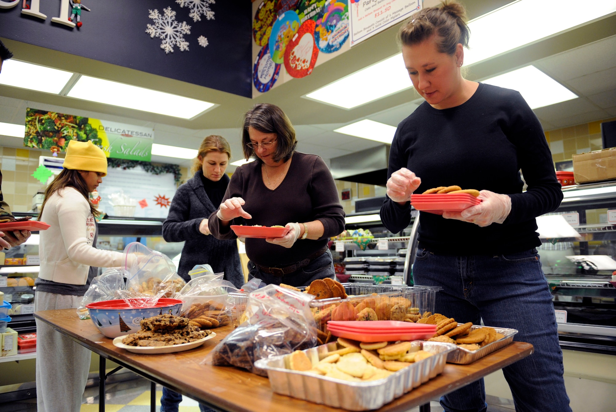 MOUNTAIN HOME AIR FORCE BASE, Idaho -- Spouses and volunteers from the base arrange an assortment of cookies along with homemade Christmas cards to be sent to deployed Airmen from Mountain Home AFB and Airmen in the dorms Dec. 8. The cookie drive, headed by Alison Browne and M.J. Maxwell, raised more than 1,600 dozen cookies for Airmen spending time away from their families. (U.S. Air Force photo/ Airman 1st Class Ryan Crane)