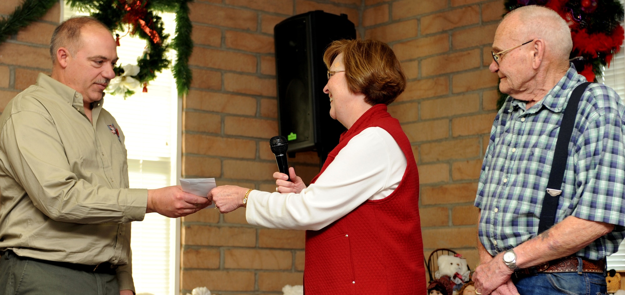 MOUNTAIN HOME AIR FORCE BASE, Idaho - Diana Hill and her father donate $1,500 to Operation Warmheart in memory of her mother, Donna Ward, during a ceremony honoring the first sergeants in the Silvercrest community of Nampa, Idaho, Dec. 6. Each Christmas the family collects the money they would normally spend on Christmas gifts for each other and donates it to the charity. The ceremony served as a way for the residents of Silvercrest to show their appreciation for Operation Warmheart, a non-profit organization that provides temporary assistance to military personnel and certain individuals and agencies from the local community. (U.S. Air Force photo/Airman Debbie Lockhart)