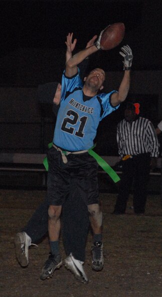 Barry Wilson, 436th Maintenance Squadron wide reciever, intercepts the ball over a 436th Civil Engineer Squadron player, before running it in for the second touchdown of the game in the Intramural Flag Football Championship Dec. 15.  MXS defeated CES 19-0. 