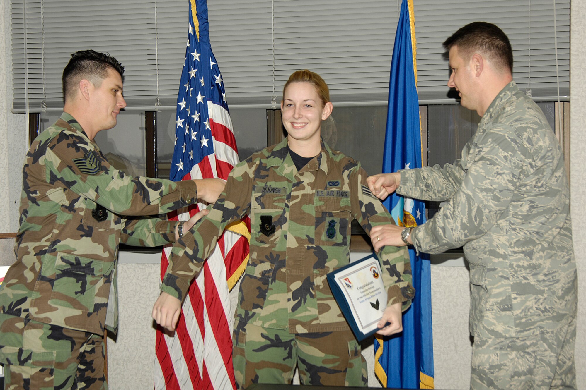 Tech. Sgt. Shon Teicheira (left), 66th Security Forces Squadron Operations noncommissioned officer in charge, and Maj. Chris Echols, 66 SFS commander, tack on a new stripe for Senior Airman Samantha DeJongh, 66th Security Forces Squadron installation patrolwoman.  Senior Airman DeJongh was selected for a Below-the-Zone promotion, allowing her to promote from airman first class to senior airman six months early.  (U.S. Air Force photo by Linda LaBonte Britt)