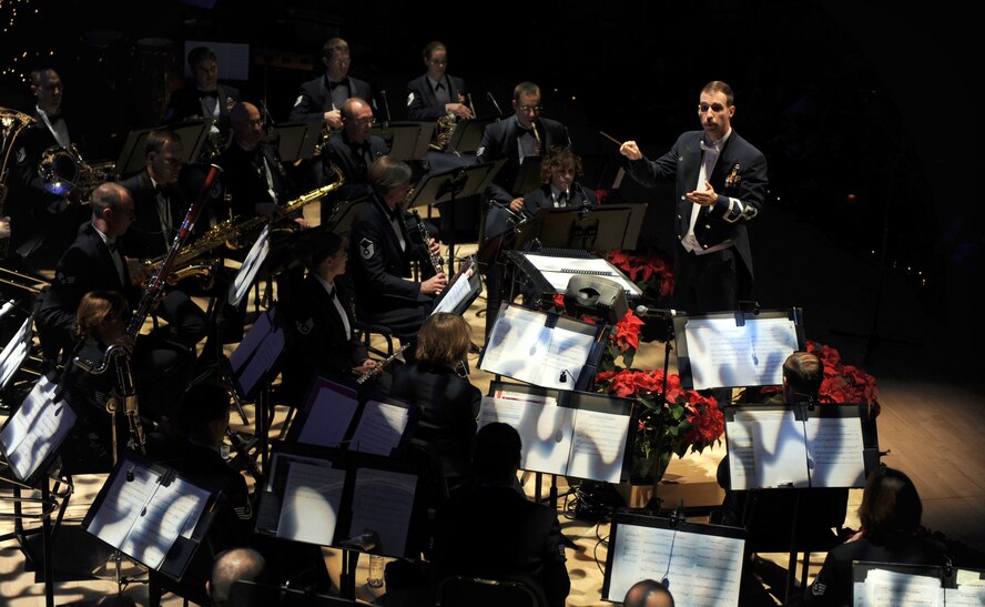 OFFUTT AIR FORCE BASE, Neb. -- The Heartland of America Band performs "The Heroes of the Season" Dec. 12 ar the Holland Performing Arts Center as deployed members from the 55th Wing greet the crowd of 2,000 metro area residents, via a video presentation behind the concert band. This performance was part of the band's annual holiday concert series. U.S. Air Force Photo by Josh Plueger