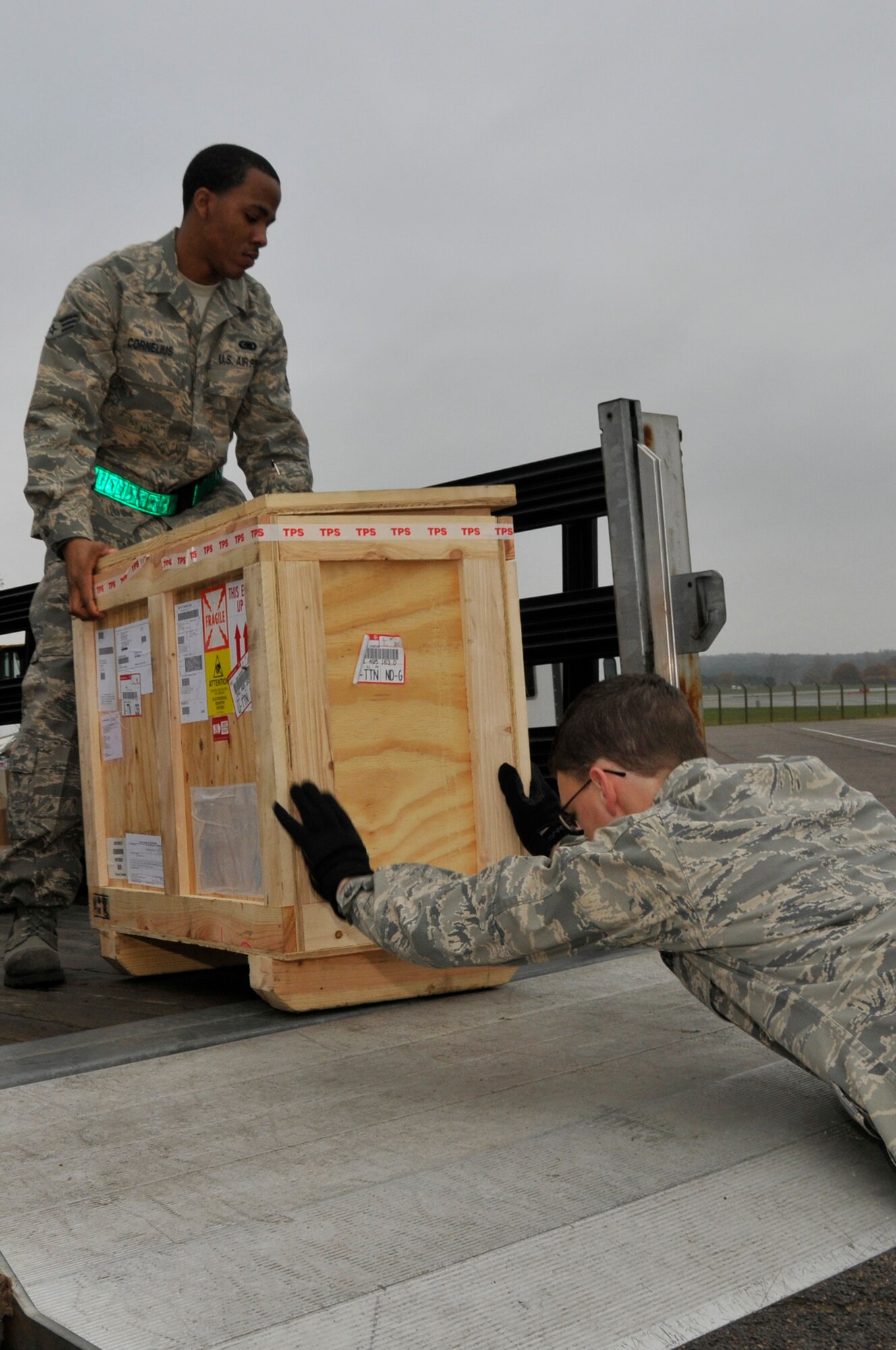 Senior Airman Douglas Cornelius  and Airman 1st Class Andrew Wachowicz, 48th Logistics Readiness Squadron flight service center technicians, load a crate containing a broken part onto their truck Nov. 14 at RAF Lakenheath, England. The Flight Service Center verifies, processes and monitors all documentation for 38 Maintenance back shops. (U.S. Air Force photo by Airman 1st Class Perry Aston) 