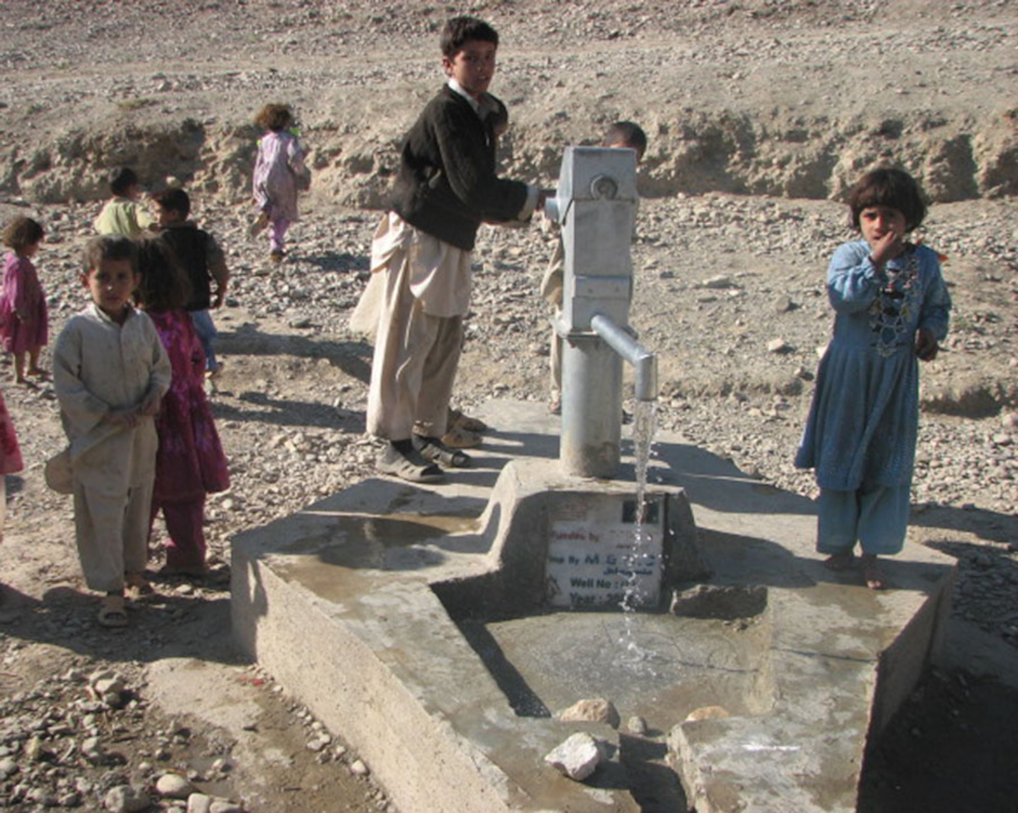 Children draw water from a well in Dara-I-Nur District.  The well was recently completed by a Nangarhar PRT contractor.  The $30,000 project included the construction of eight wells in six districts and was finished in December. (Courtesy photo)
