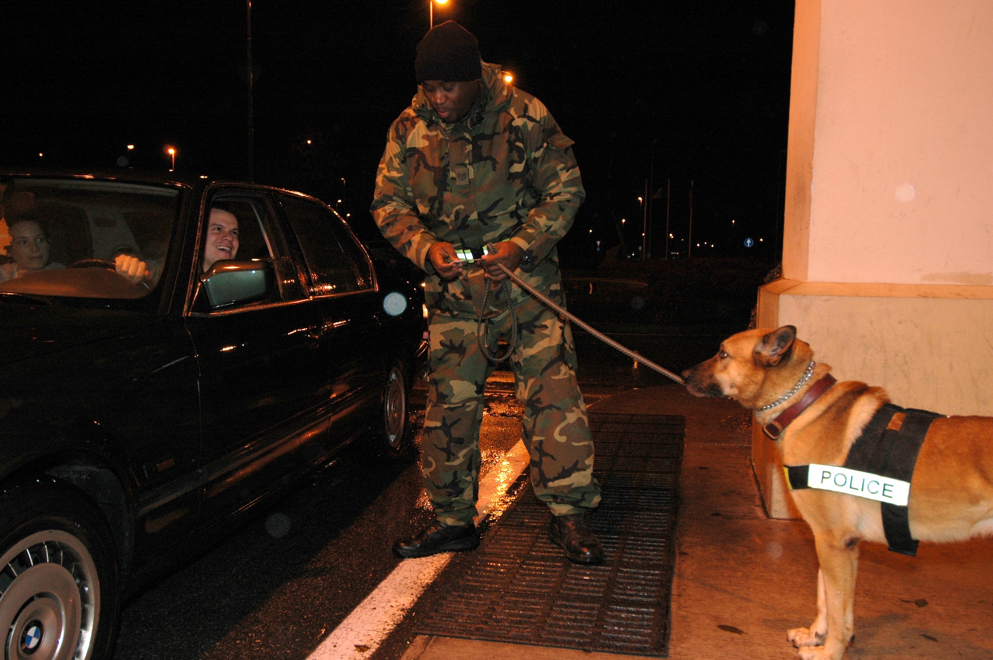 Staff Sgt. Charleston Calhoun of the 31st Security Forces Squadron and his partner Arco, check Senior Airman Jared Watson's common access card as part of a random antiterrorism measure check at the main gate Dec. 16. The base conducted more than 3,200 RAMs this past year, which is just one aspect of the base's antiterrorism program. Airman Watson is assigned to Armed Forces Network Detachment 8. (U.S. Air Force photo/Staff Sgt. Lindsey Maurice)