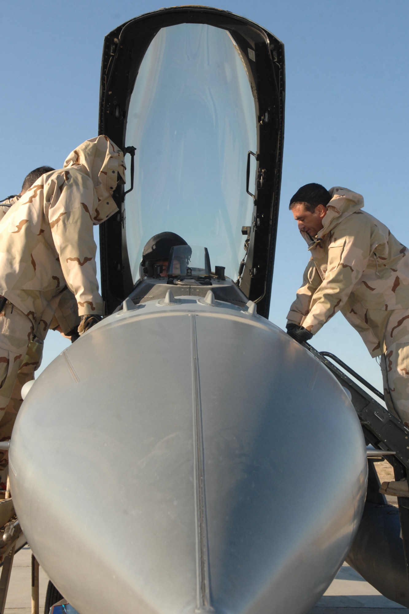 Staff Sgt. Alan Raia(right) and two other Airmen receive egress training on an F-16 at Kirkuk Regional Air Base, Iraq, Dec. 16.  The training provided the firefighters hands-on familiarization with the jet in case of an emergency requiring egress.  The firefighters are part of the 506th Expeditionary Civil Engineering Squadron.  Sergeant Raia is deployed from Westover Air Reserve Base, Mass. (U.S. Air Force photo/Senior Airman Randi Flaugh)