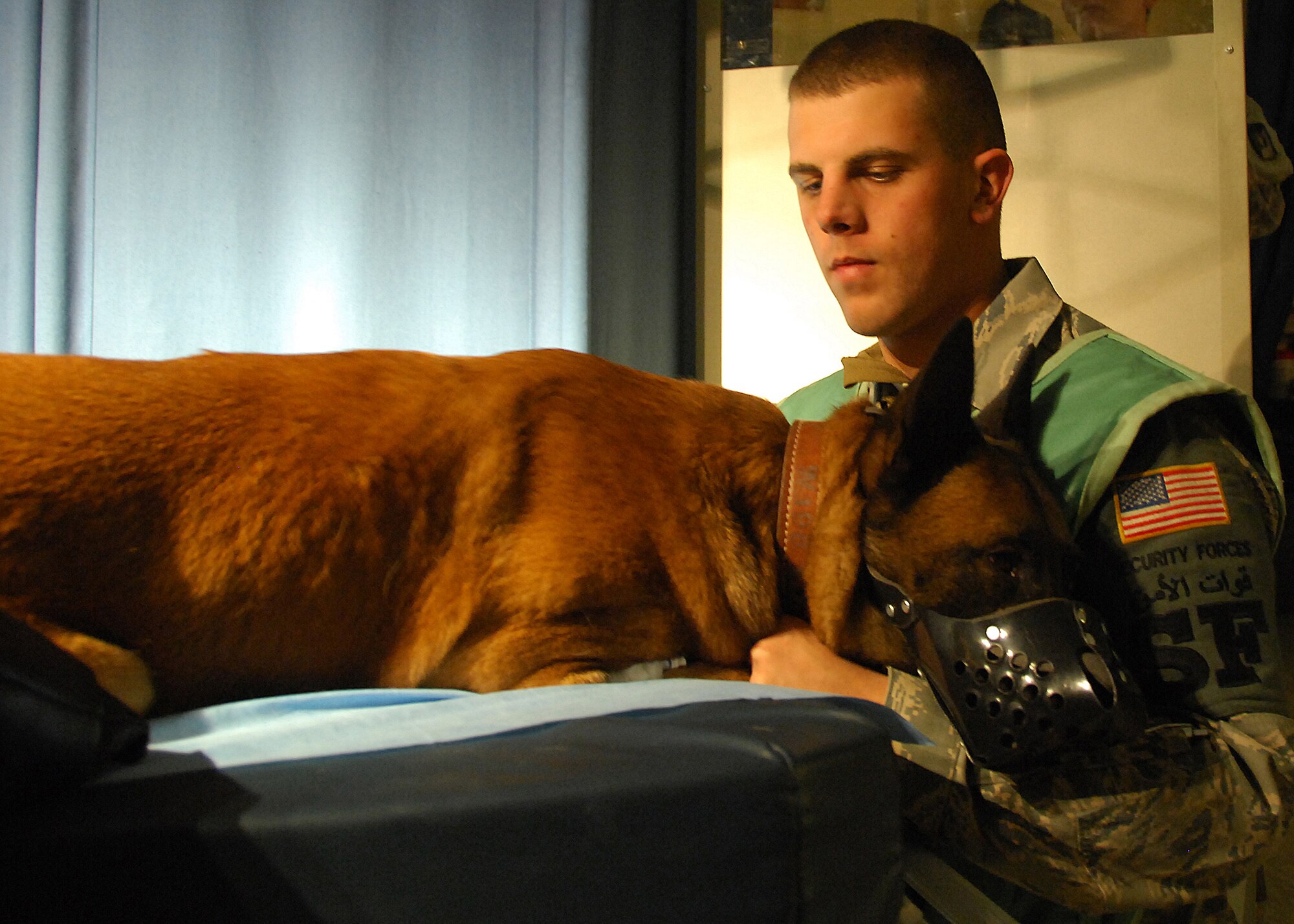 SOUTHWEST ASIA -- Senior Airman Daren Marshall, 386th Expeditionary Security Forces Squadron military working dog handler, comforts his K-9, Zack, during an X-ray session on Dec. 13 at an air base in Southwest Asia. Zack received an X-ray to see how his pneumonia has cleared since his last visit. Airman Marshall is assigned to the 386th Expeditionary Security Forces Squadron and is deployed from F.E. Warren Air Force Base, Wyo. (U.S. Air Force photo/ Tech. Sgt. Raheem Moore)