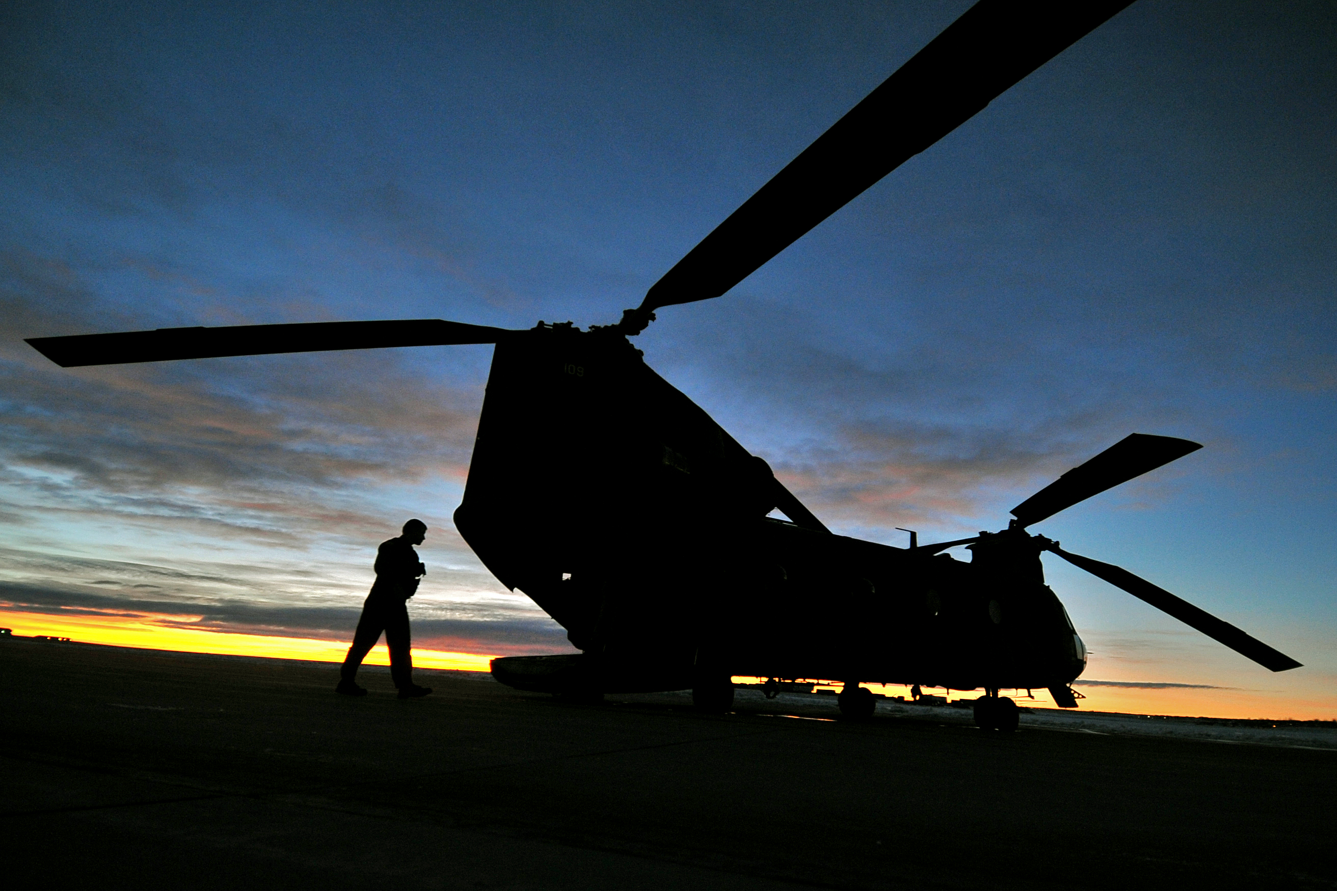 A CH-47 Chinook helicopter crew prepares the aircraft for an early ...