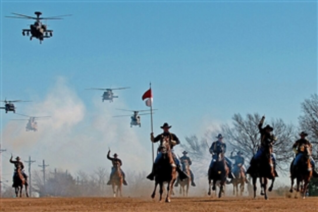 Following the casing of the brigade, battalion and division colors, soldiers assigned to the 1st Cavalry Division Horse Detachment perform a cavalry charge accompanied by a helicopter flyover performed by the 1st Cavalry Division Air Cavalry Brigade on Fort Hood's Cooper Field, Texas, Dec. 12, 2008.
