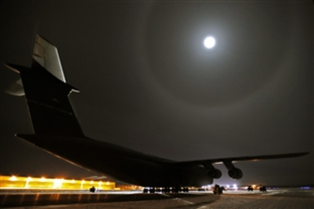 A C-5M Super Galaxy, largest aircraft in the Air Force, is lit by the largest moon of the year while it sits on the tarmac for a period of 24 hours with temperatures low as -25 degrees during cold weather testing on Eielson Air Force Base, Alaska, Dec. 12, 2008. This is the first Galaxy with new CF-6 engines, pylons and auxiliary power units, with upgrades to the aircraft's skin and frame, flight controls, landing gear and the pressurization system that went through cold weather testing.