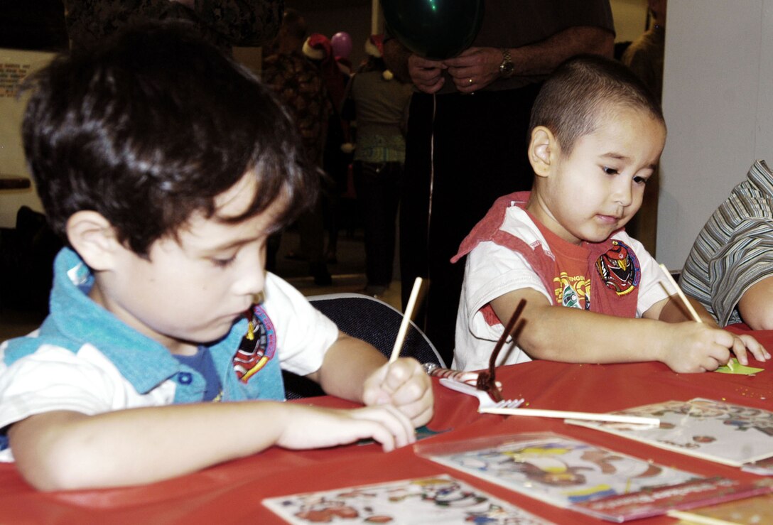 Joseph Barr, 5, and his brother, Jasper, 3, participate in craft-making at the U.S. Marine Corps Forces, Pacific Headquarters and Service Battalion holiday party at the Pollock Theater Dec. 18. The night featured food, music, crafts and face painting for the children.