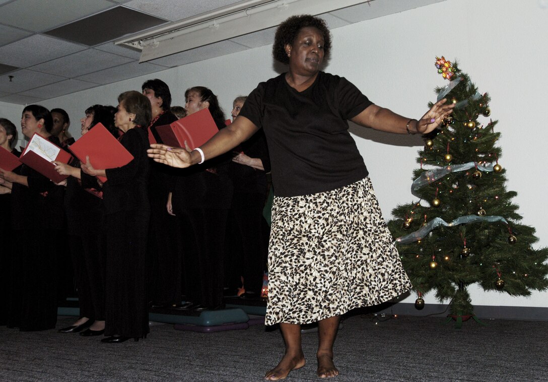 Jeannette Powell-Campbell, MarForPac administration chief dances as the Honolulu Blend Chorus sings traditional holiday songs during the U.S. Marine Corps Forces, Pacific Headquarters and Service Battalion holiday party at the Pollock Theater Dec. 18.