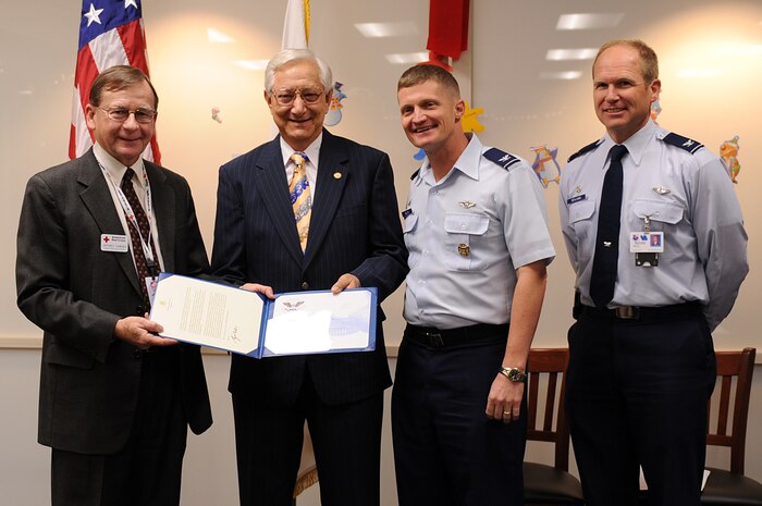 Jeffrey Varnes, CEO of the Southern Nevada Chapter of the American Red Cross, Col. Dave Belote, 99th Air Base Wing commander, and Col. Christian Benjamin, 99th Medical Group commander, present Stuart Hess with the President's Volunteer Service Award at the Mike O' Callaghan Federal Hospital, Nellis Air Force Base, Nev., Dec. 15, 2008. Mr. Hess, American Red Cross hospital chairman of volunteers, received the gold-level award for providing more than 500 volunteer hours over five years at the base hospital. (U.S. Air Force Photo / Airman 1st Class Stephanie Rubi, RELEASED)
