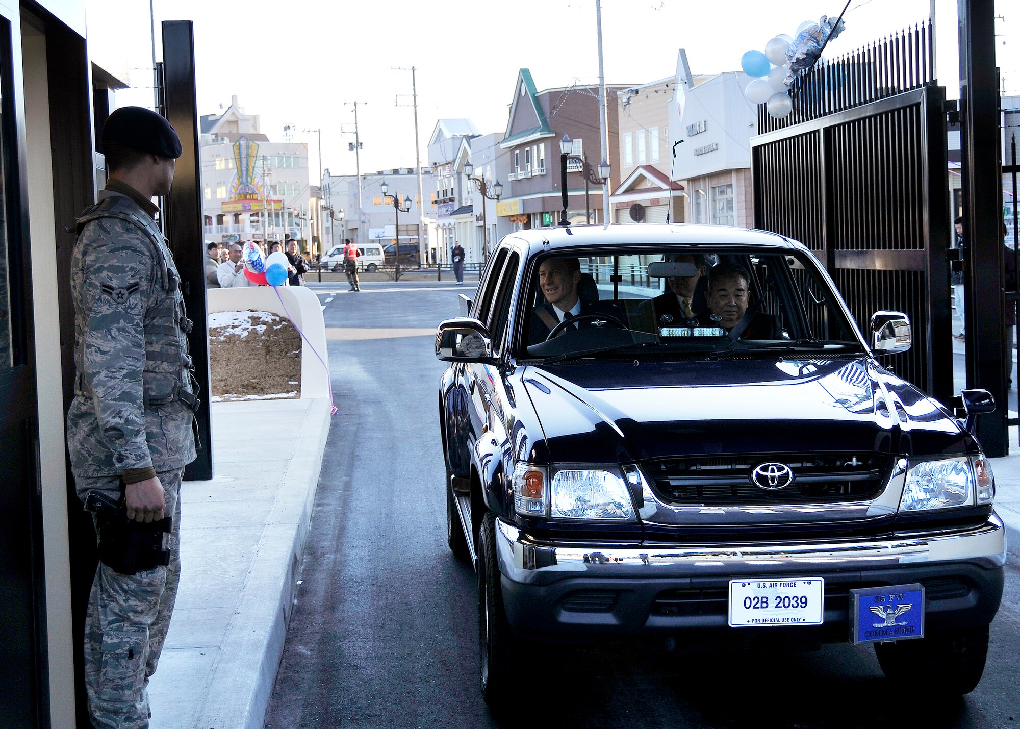 MISAWA AIR BASE, Japan -- Col. David Stilwell, 35th Fighter Wing commander and the Misawa Mayor Kazumasa Taneichi, drive through the newly constructed main gate being the first people to enter and have their Ids checked by A1C Nicolas Gonzalez, 35th Security Forces squadron on Dec. 16, 2008.  The new main gate was designed to help the flow of traffic by having three lanes.  (U.S. Air Force photo by Senior Airman Chad Strohmeyer)