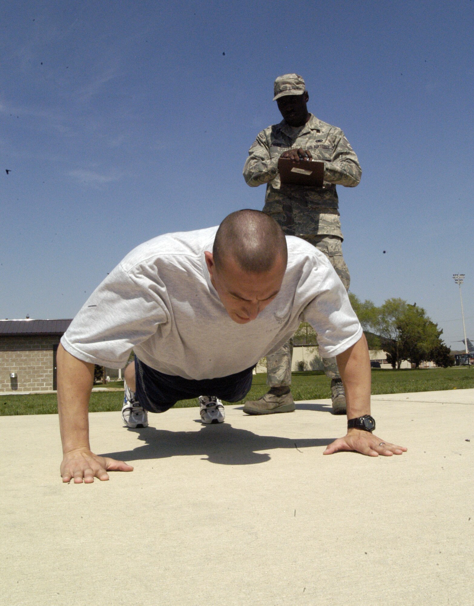 Staff Sgt. Stephen Jenkins, 436th Logistics Readiness Squadron physical training leader, times and records Tech. Sgt. Paul Nelson's push-ups and sit-ups for the annual fitness test. (U.S. Air Force photo/Airman 1st Class Shen-Chia Chu)