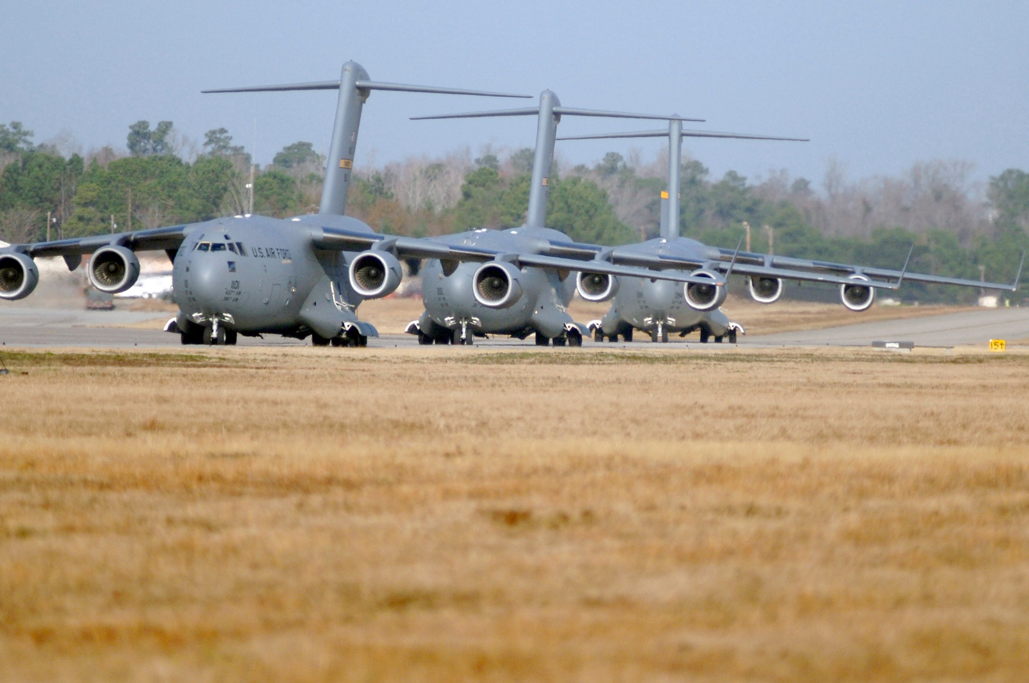 Charleston AFB C-17's taxi on the flight line prior to being cleared for takeoff as part of a 13 aircraft formation training mission here Dec. 18. The formation flight demonstrated the U.S. Air Force's strategic capability. The training mission included airdrops over North Auxiliary Airfield in Orangeburg, S.C., and aerial refueling training. (U.S. Air Force photo/Staff Sgt. Marie Cassetty)