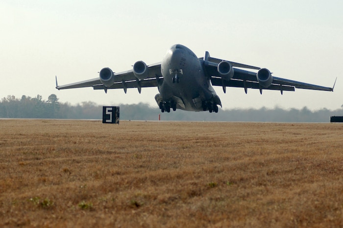 A Charleston AFB C-17 takes off as part of a 13 aircraft formation training mission here Dec. 18. The formation flight demonstrated the U.S. Air Force's strategic capability. The training mission included airdrops over North Auxiliary Airfield in Orangeburg, S.C., and aerial refueling training. (U.S. Air Force photo/Staff Sgt. Marie Cassetty)