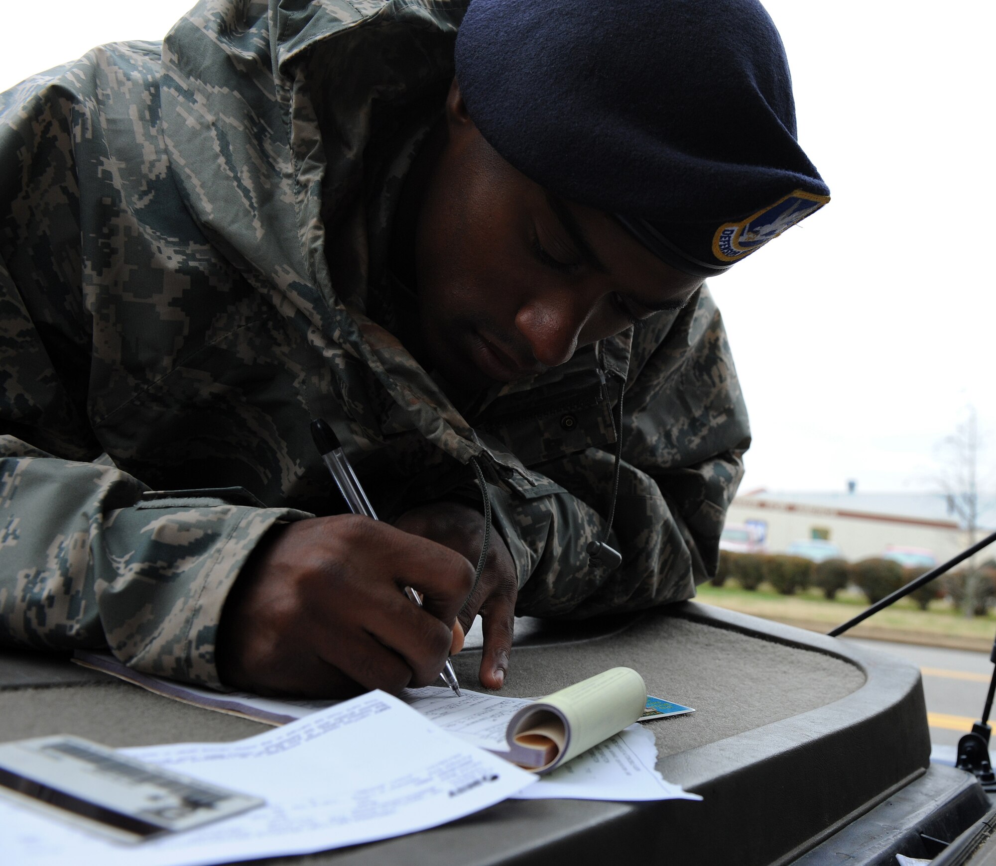 LANGLEY AIR FORCE BASE, Va. – Airman 1st Class Kelli Sampson, 1st Security Forces Squadron installation patrolman, writes a citation for a speeding motorist on Sweeney Boulevard Dec. 18. Security forces set up observation points in high target areas in order to deter motorists from speeding.  (U.S. Air Force photo/Airman 1st Class Zachary Wolf)