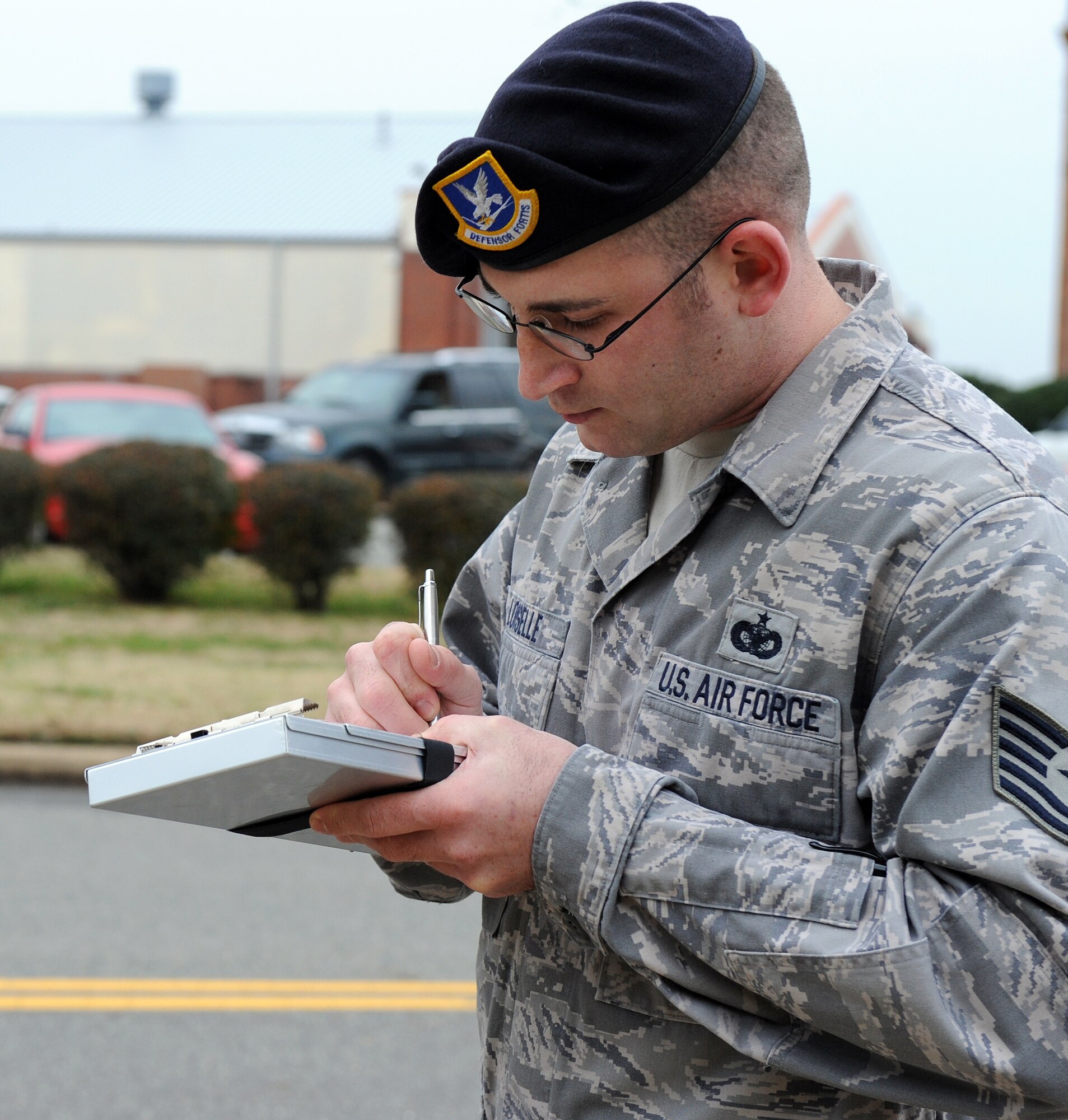 LANGLEY AIR FORCE BASE, Va. – Tech. Sgt. Matthew Loiselle, 1st Security Forces Squadron assistant non-commissioned officer in charge, writes a citation for a speeding motorist on Sweeney Boulevard Dec. 18.  Security forces set up observation points in high target areas in order to deter motorists from speeding.  (U.S. Air Force photo/Airman 1st Class Zachary Wolf)