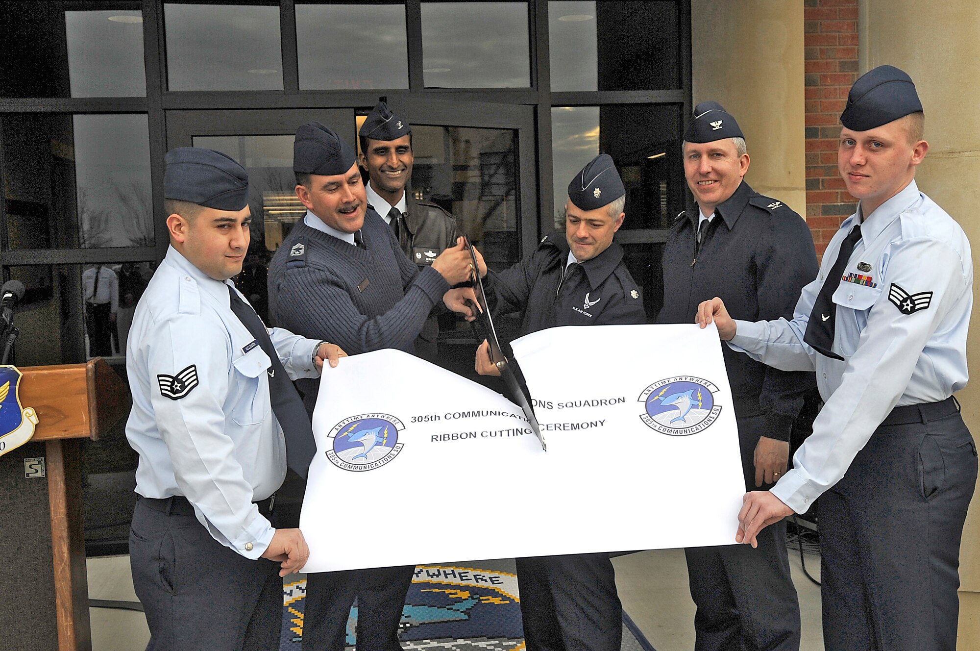 A ribbon cutting ceremony for the new - and long-awaited - 305th Communication Squadron building drew a large crowd Monday. From left to right, Staff Sgt. Chris McClendon, 305th CS, Chief Master Sgt. Mark Harper, 305th CS superintendent, Col. Balan Ayyar, 305th Air Mobility Wing commander, Lt. Col. Robert Licciardi, 305th CS commander, Col. Michael Carrell, 305th Mission Support Group commander, and Senior Airman Brandon Talmadge, 305th CS. (U.S. Air Force photo/Carlos Cintron)