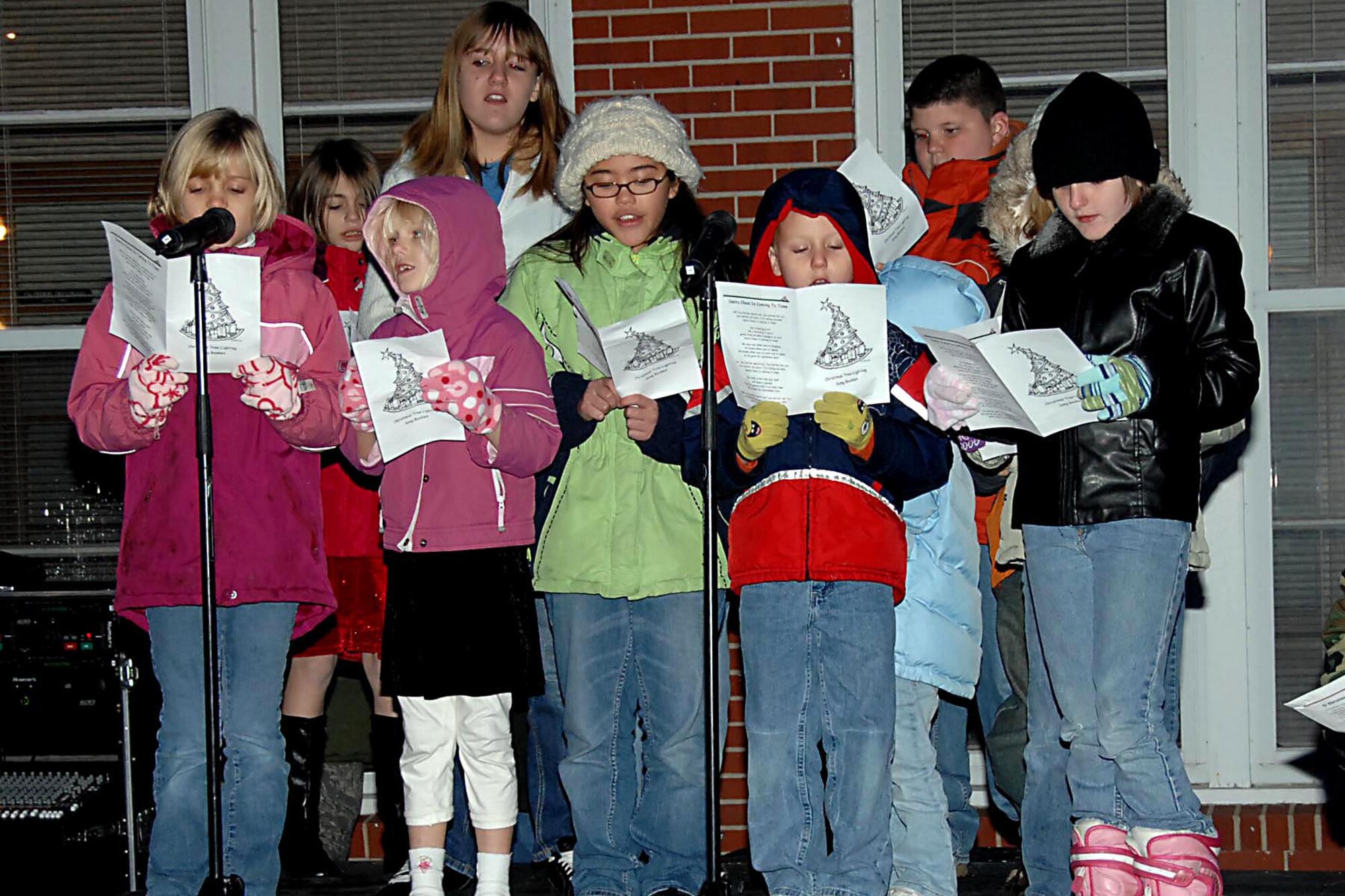 Offutt Air Force Base, Neb. --- Members of the Chapel Children's Choir sing Christmas carols and wait for Santa to ride by during the official HolidayTree Lighting Ceremony Dec. 4 at the Strategic Air Command Memorial Chapel. The Offutt Holiday Tree is an 8 foot live tree that will continue to grow over the years. (U.S. Air Force Photo By Kendra Williams)