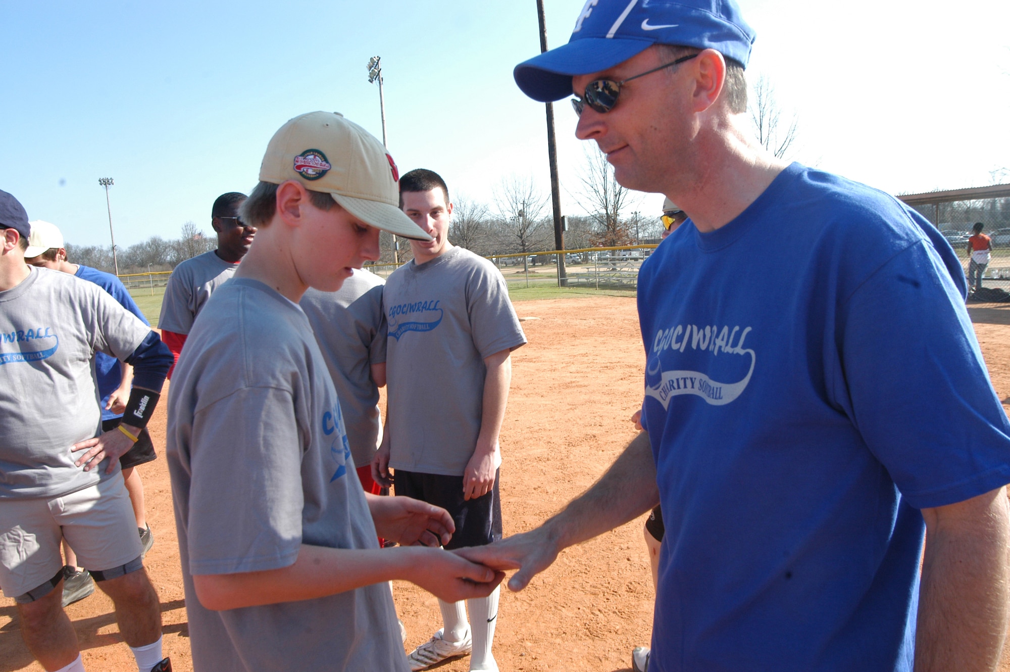 Col. Warren Berry gave a 78th ABW coin to each member of the the Warner Robins American Little League world champion team that played a  mixed softball game with members of the Company Grade Officer's Council in February. U. S. Air Force photo by Sue Sapp    