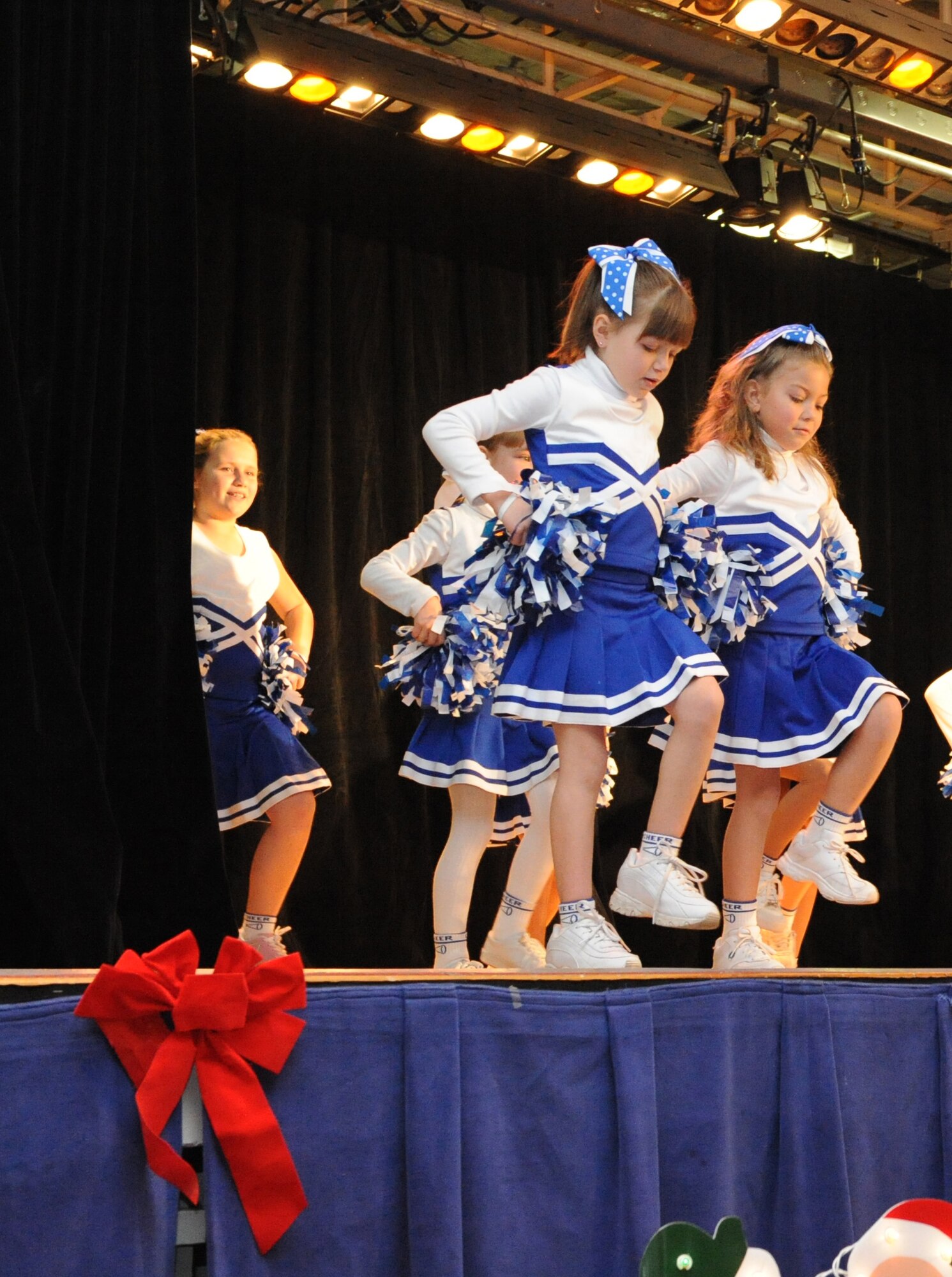 The Holloman cheerleaders, also called the Holloman Eagles, give a performance during the International Children's Festival at the Community Center at Holloman Air Force Base, N.M., Dec. 13. The cheerleaders, all from kindergarten through fifth grade, performed different holiday cheers for those who attended the festival. (U.S. Air Force photo/Airman 1st Class Sondra Escutia)