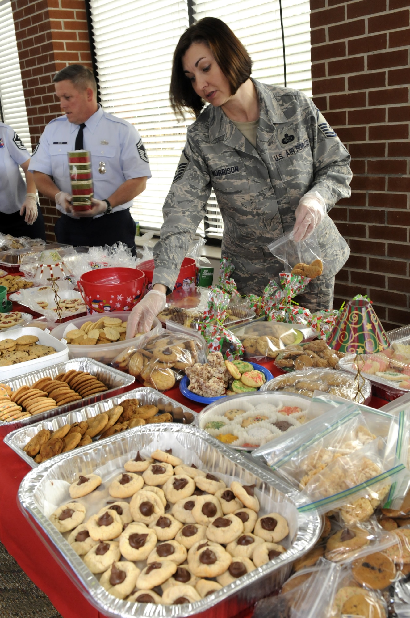 MSgt. Shondi Morrison, 78th FSS base career advisor, bags cookies and assorted goodies at Wynn Dining facility for Airmen residing in Robins' dorms. The undertaking was a Team Robins event with cookies  donated from different groups, organizations, spouses and girl scouts on base. The volunteers filled the bags and decorated them with a candy cane and bow. The bags were delivered this week. U. S. Air Force photo by Sue Sapp