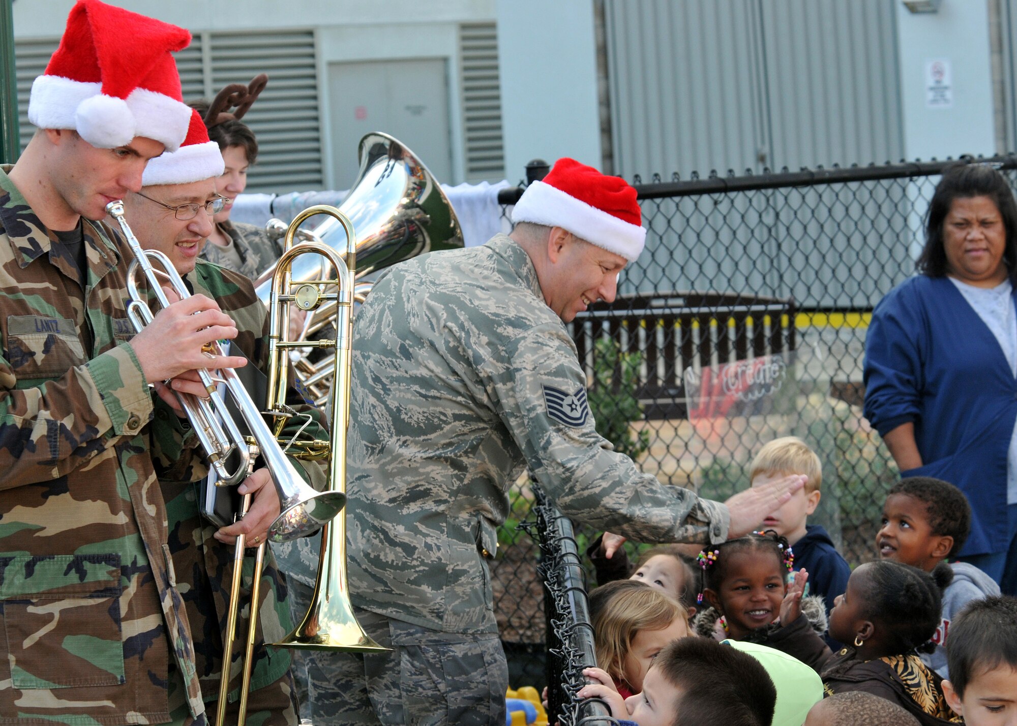 Tech. Sgt. Edward Schubert gives "hi 5's" to audience members as Senior Airman James Lantz plays along. The meet-and-greet took place during the Band of the Golden West's performance at the Child Development Center, Los Angeles AFB, Dec. 15. (Photo by Atiba Copeland)



