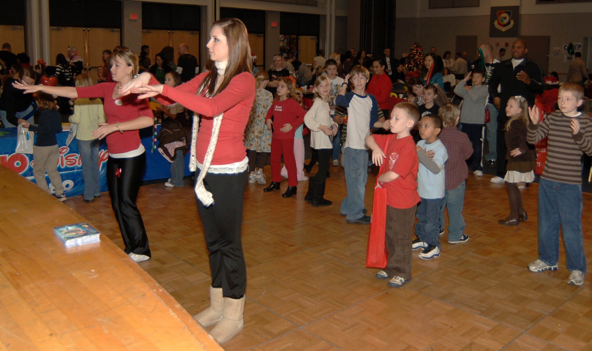 MCCONNELL AIR FORCE BASE, Kan. -- Radio Disney disc jockeys start the fun and dancing with the “Macarena” moves for Team McConnell children at Santa’s visit in the Dole Center, Dec. 13. (Photo by Airman 1st Class Maria Ruiz)