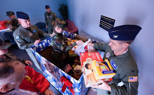 (Center) Staff Sgt. Melisa Reddy, 436th Airlift Wing Command Post, hands toys to Col. Steven Harrison, 436th Airlift Wing commander, Dec. 16.  The toys were collected as part of the annual Toys for Tots drive.  The toys will be given to needy children during the holidays.  (U.S. Air Force photo/Thomas Randle)
