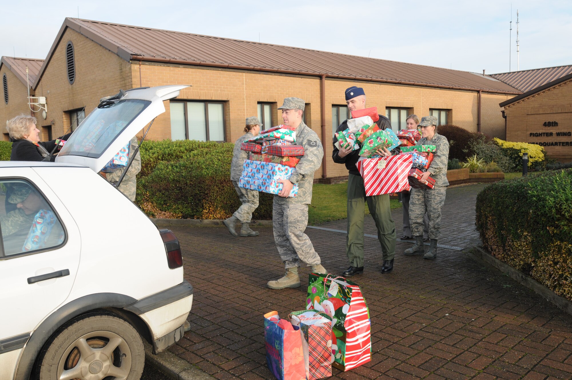 48th Fighter Wing personnel line up to help load a car with Christmas presents for the Sure Start Children’s Centre in Thetford. The Christmas presents were collected over a ten-day period and delivered to the children’s centre Dec. 18. (U.S. Air Force photo by Senior Airman Kristopher Levasseur)