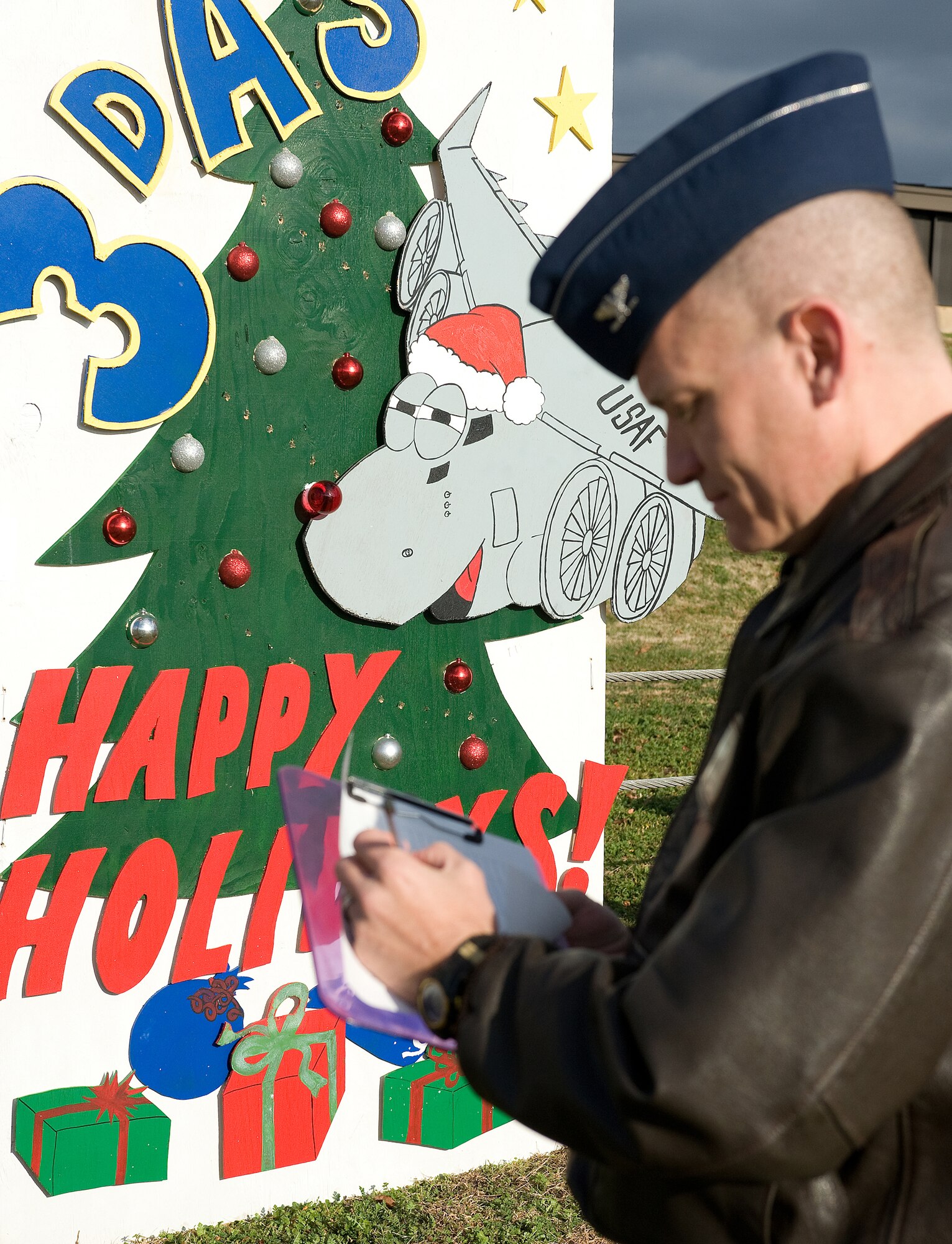 Col. David Horton, 436th Operations Group commander, reviews Holiday Lane cards during a judging ceremony Dec. 12.  Seven Dover squadrons created plywood holiday cards for the event.  The 3rd Airlift Squadron took first place.  (U.S. Air Force Photo/Tom Randle)