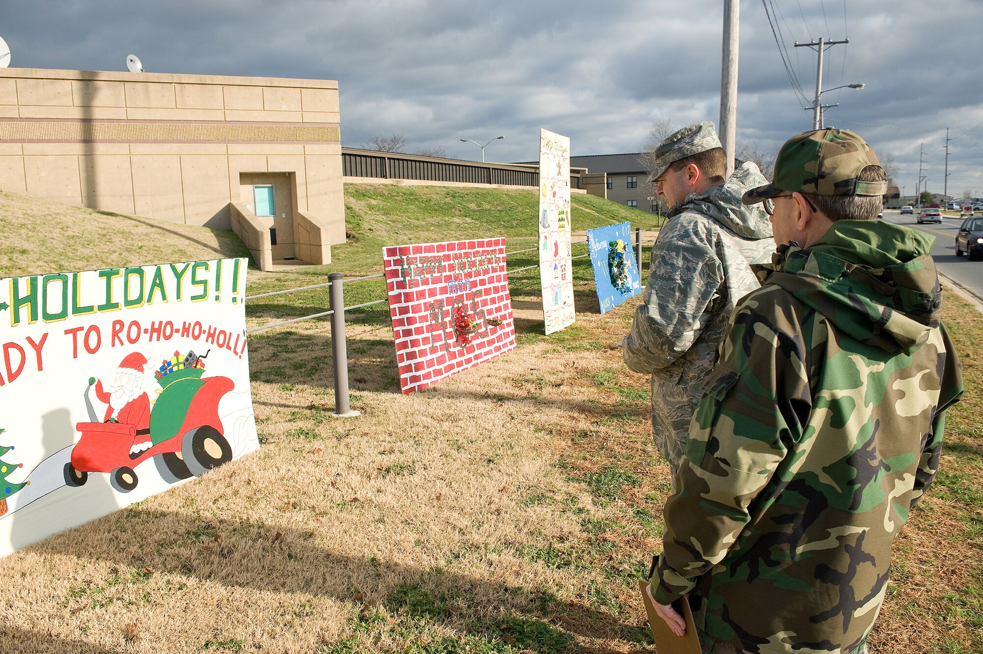 (Left) Chief Master Sgt. Peter Cawthon, 436th Medical Group superintendant, and Col. Timothy Pendergrass, 436th Medical Group commander, review the Holiday Lane cards during a judging ceremony Dec. 12.  Seven Dover Squadrons created plywood holiday cards for the event.  The 3rd Airlift Squadron took first place.   (U.S. Air Force Photo/Tom Randle)