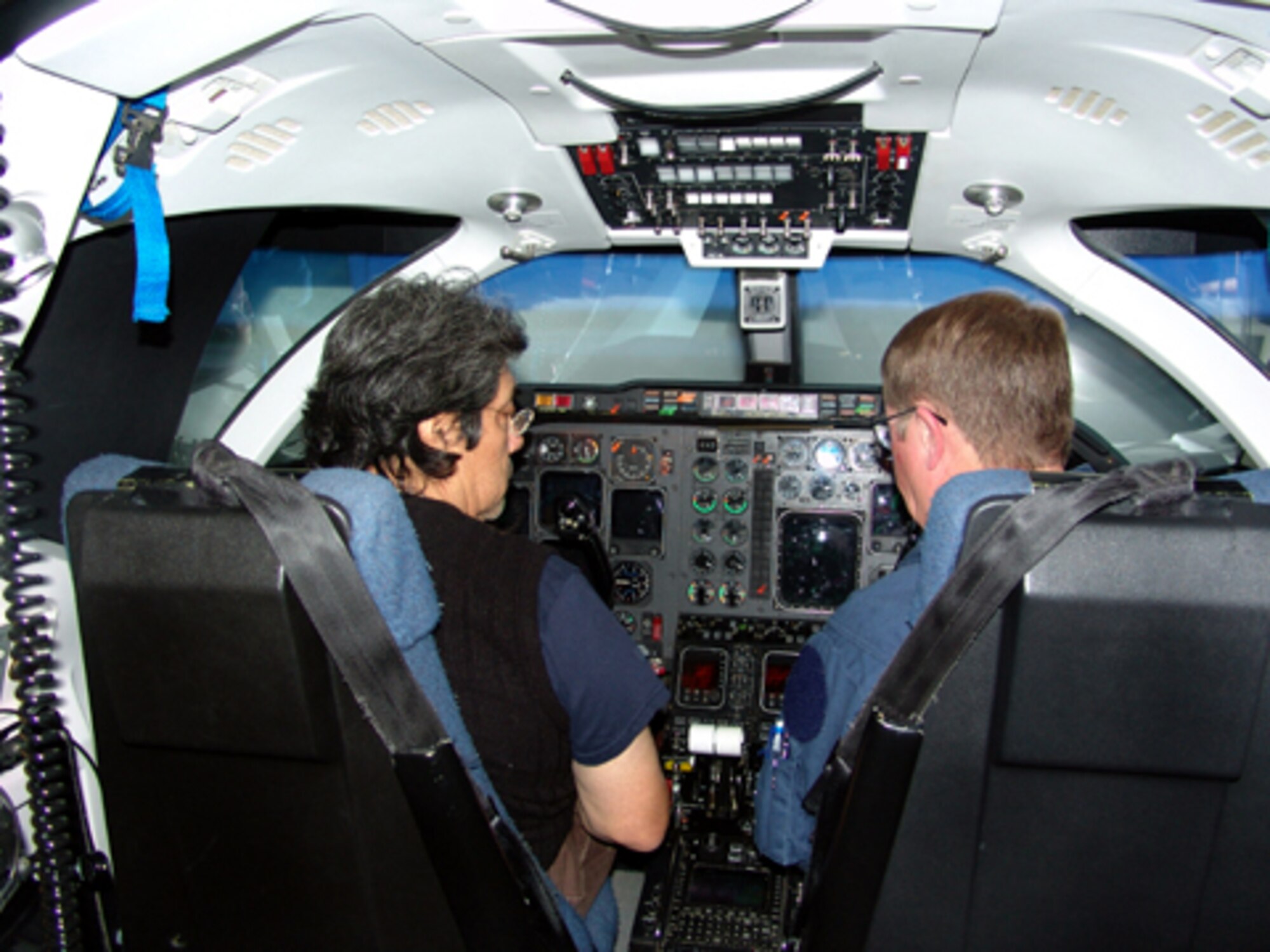 Tim Thomson, Lear Siegler Inc. simulator instructor, flies a T-1A Jayhawk flight simulator with Carlos Rosales, honorary commander of the 14th Operation Support Squadron Monday. Rosales spent the day touring the 14th OSS to better understand its mission.  (U.S. Air Force photo)