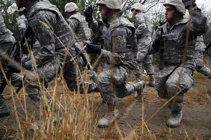 Airmen Basic trainees in body armor use hand signals as they take a knee during a tactical drill movement down an improvised explosive device lane Dec. 17 as part of the five-day deployment exercise called the Basic Expeditionary Airman Skills and Training, or BEAST, which kicked off Dec. 15 at Lackland Air Force Base, Texas. The BEAST is the newly built complex added into the extended 8.5 week Basic Military Training curriculum that began Nov. 5. (U.S. Air Force photo/Staff Sgt. Desiree N. Palacios) 