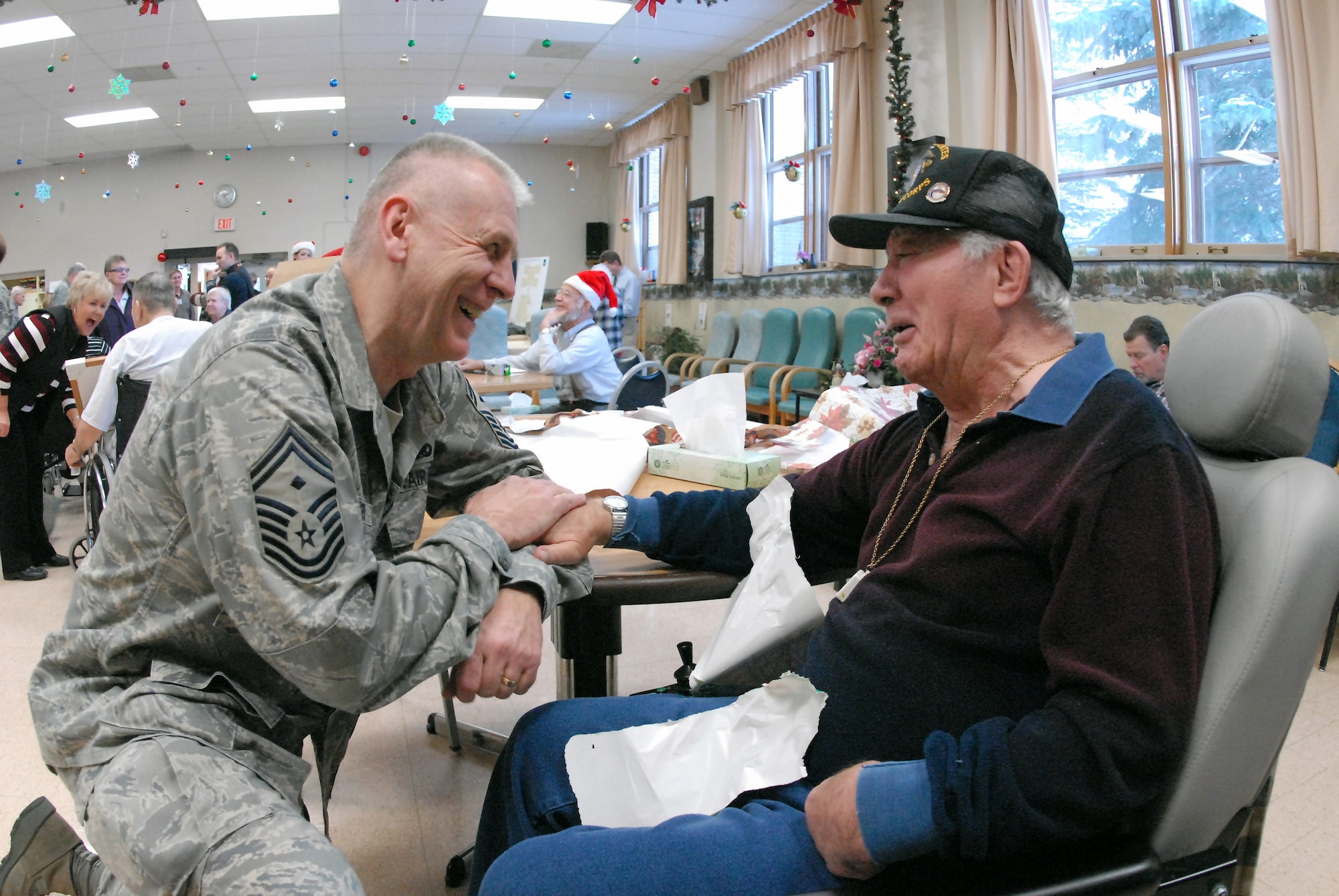 Senior Master Sgt. Paul Tangen visits with Marine veteran Marvin Schiermeister at the North Dakota Veteran's Nursing Home Dec. 10 in Lisbon, N.D. The gifts are given to veterans at the nursing home by the North Dakota Air and Army National Guard each December using funds raised through personal donations given by the North Dakota National Guard members. Sergeant Tangen is the the 119th Wing first sergeant. (U.S. Air Force photo/Senior Master Sgt. David H. Lipp)