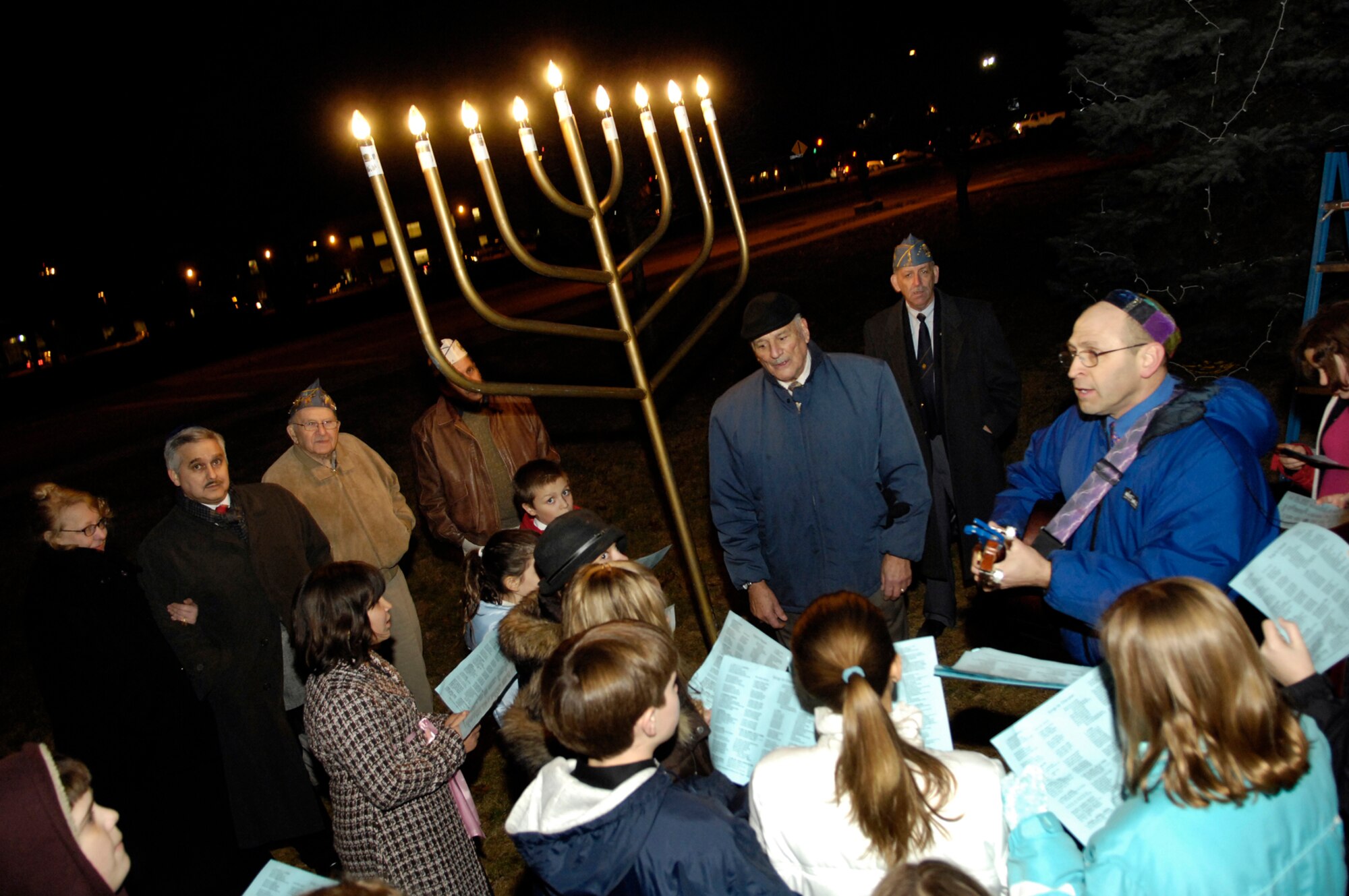 Howard Worona (right), Hanscom Middle School music teacher, accompanies a group of singers at Hanscom's Menorah Lighting Ceremony, held at the Base Chapel Dec. 16. This year, Hanukkah, the Jewish Festival of Lights, begins Dec. 21 and ends Dec. 29.  (U.S. Air Force photo by Mark Wyatt)