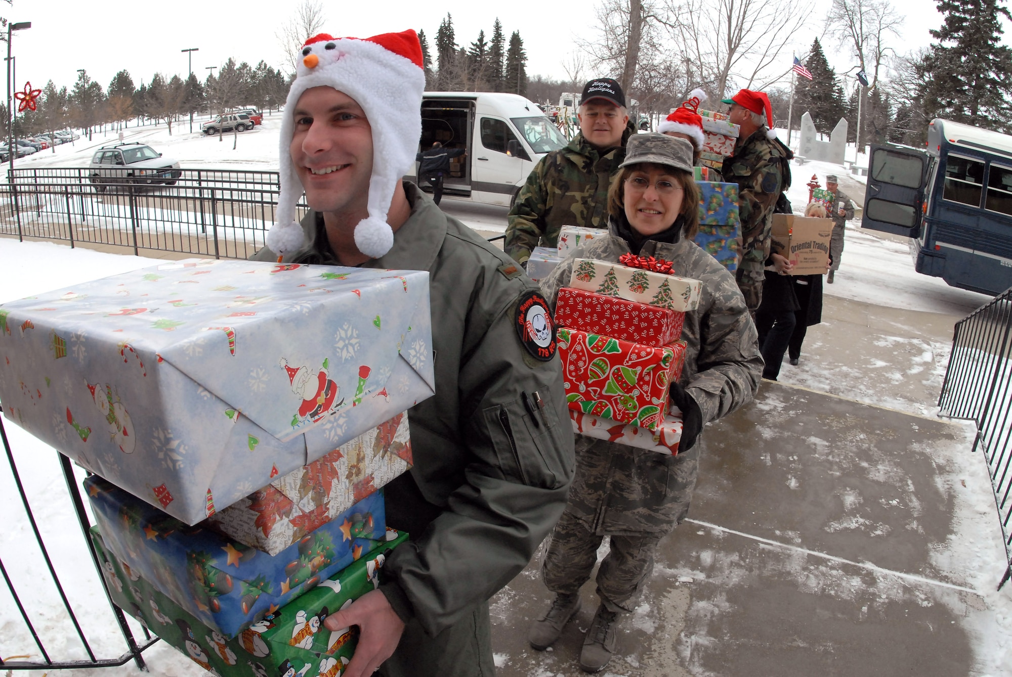 2nd Lt. Roy Thomsen and Chief Master Sgt. Paula Johnson carry Christmas gifts into the North Dakota Veteran's Nursing Home Dec. 10 in Lisbon, N.D. The gifts are given to veterans at the nursing home by the North Dakota Air and Army National Guard each December using funds raised through personal donations given by the North Dakota National Guard members. Lieutenant Thomsen and Chief Johnson are North Dakota Air National Guard members. (U.S. Air Force photo/Senior Master Sgt. David H. Lipp) 
