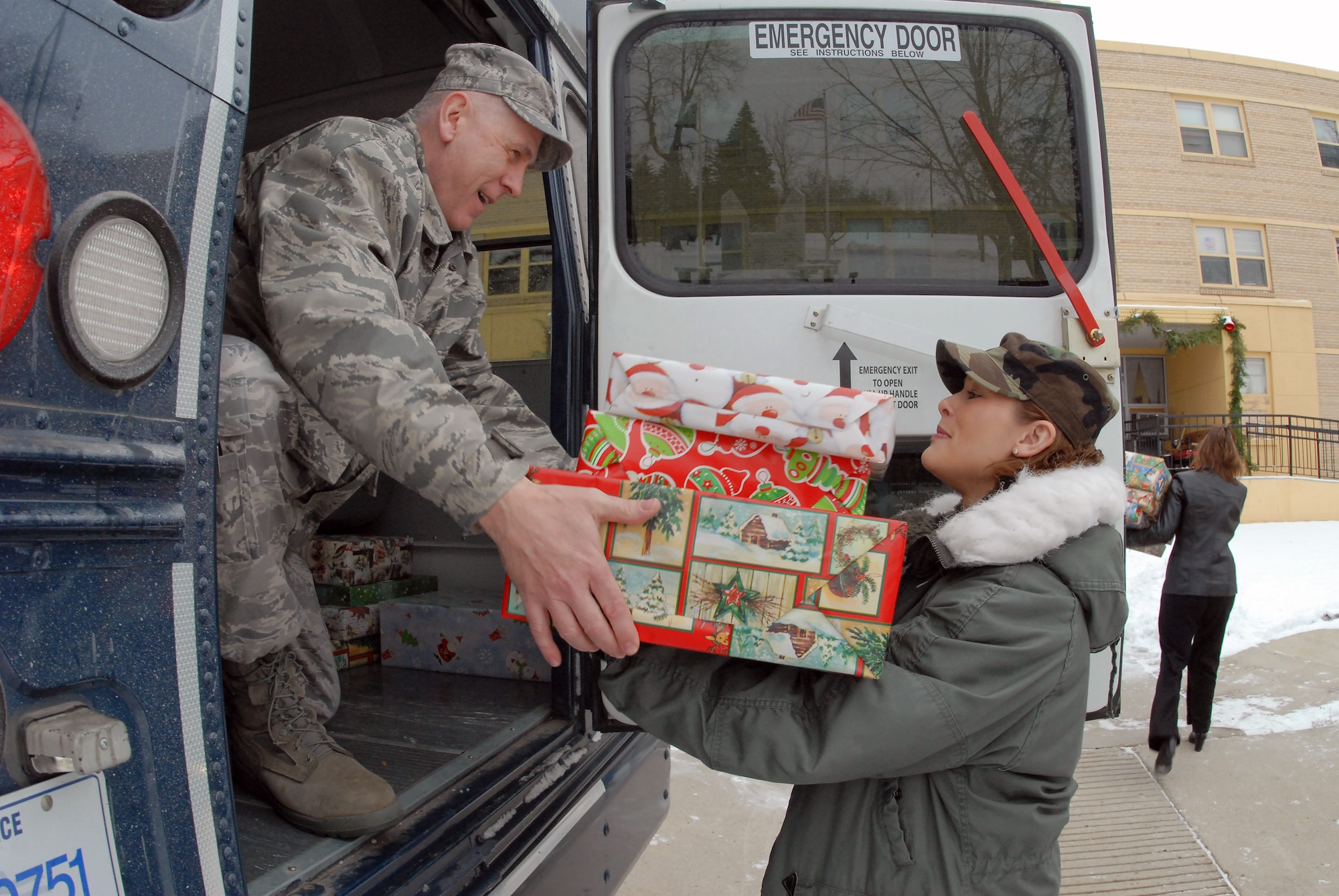 Senior Master Sgt. Paul Tangen hands Christmas gifts to Master Sgt. Merri Jo Filloon as they deliver presents to the North Dakota Veteran's Nursing Home Dec. 10 in Lisbon, N.D. The gifts are given to veterans at the nursing home by the North Dakota Air and Army National Guard each December using funds raised through personal donations given by the North Dakota National Guard members. Sergeant Tangen is the the 119th Wing first sergeant, and Sergeant Filloon is assigned to the 119th Mission Support Flight. (U.S. Air Force photo/Senior Master Sgt. David H. Lipp)  