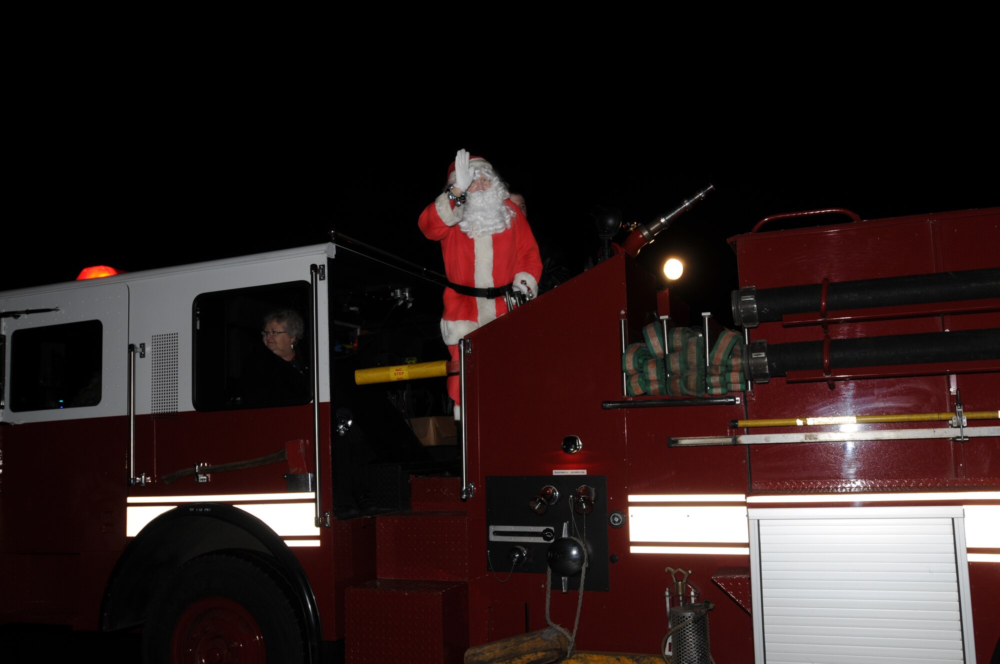 Santa Claus rides off on a fire truck after visiting the children Dec. 16 on RAF Feltwell, England. Santa visits RAF Feltwell every year to deliver candy canes and talk to the young children. (U.S. Air Force photo by Senior Airman Kristopher Levasseur)